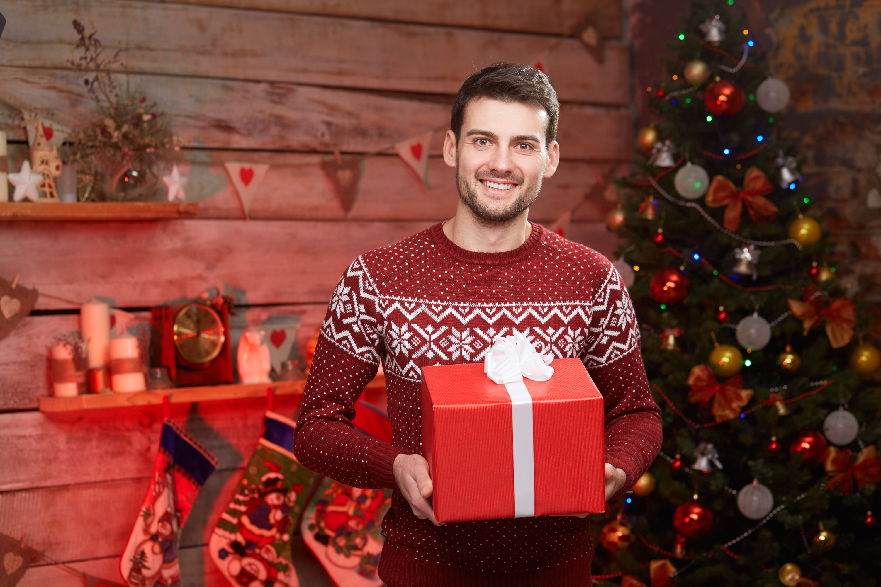 Ein glücklicher Mann mit einem Geschenkkarton während der Weihnachtszeit | Quelle: Shutterstock