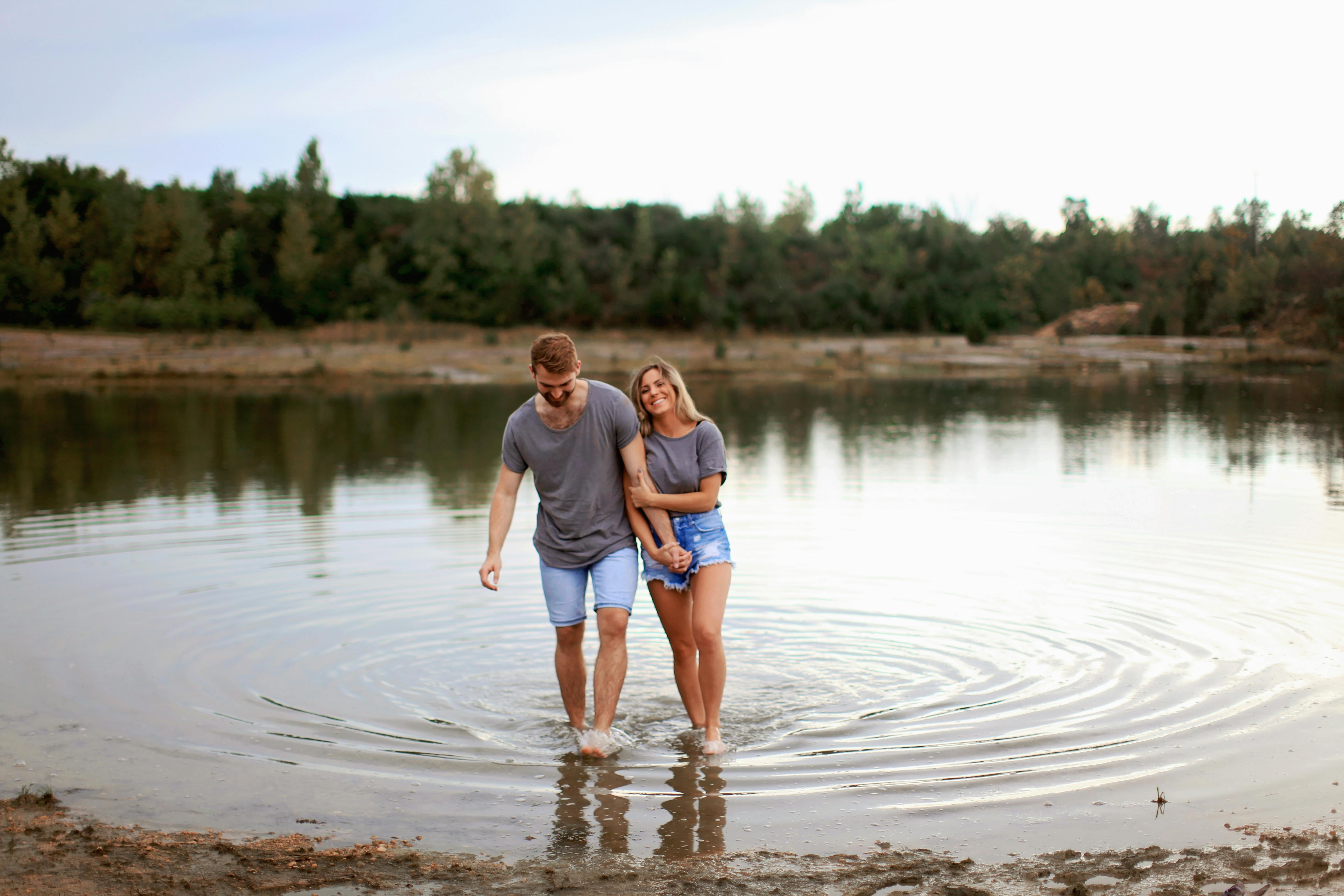 Ein glückliches Paar beim Spaziergang im Wasser | Quelle: Pexels