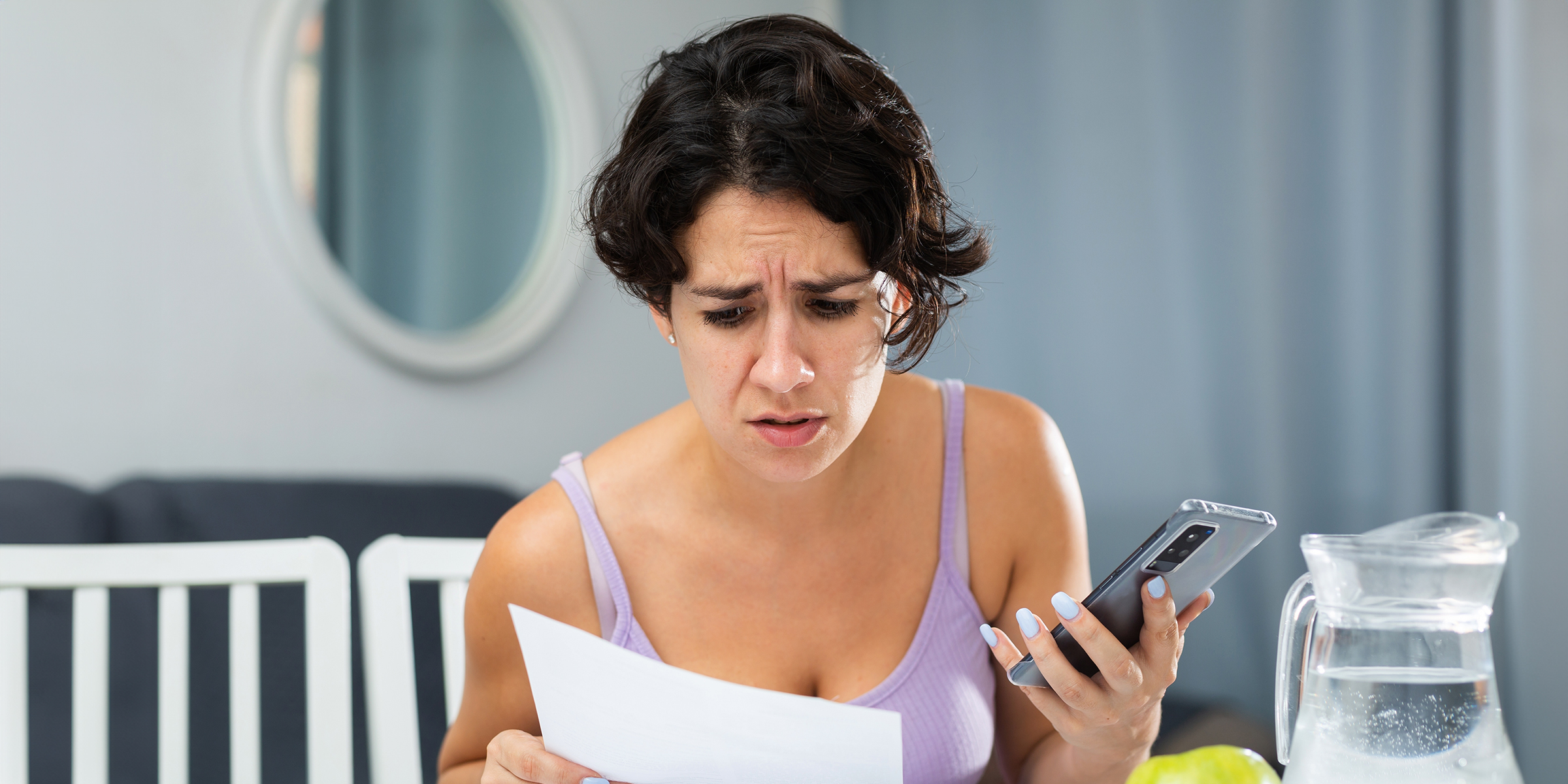 Eine stirnrunzelnde Frau, die ein Dokument r studiert | Quelle: Shutterstock