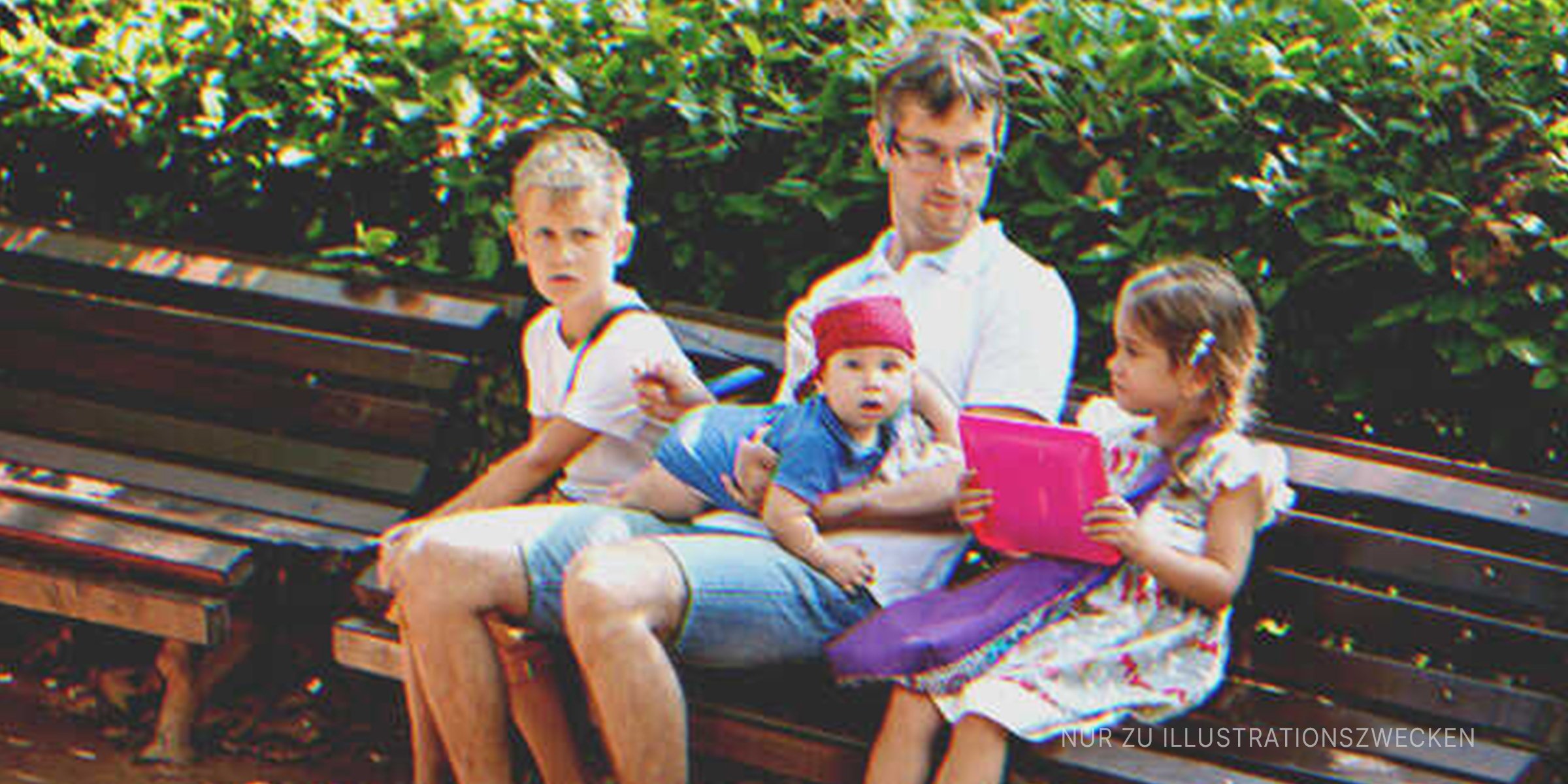 Mann sitzt mit 3 Kindern auf Bank. | Quelle: Shutterstock
