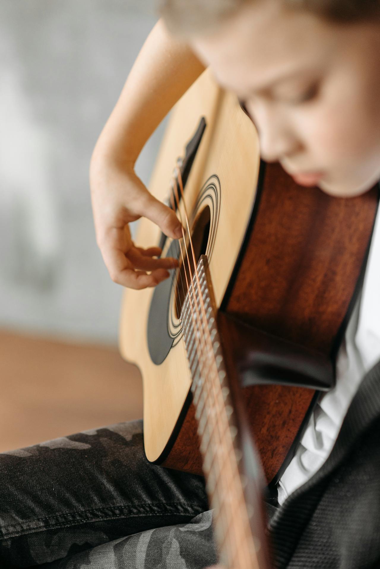 Ein Junge spielt auf einer Gitarre | Quelle: Pexels