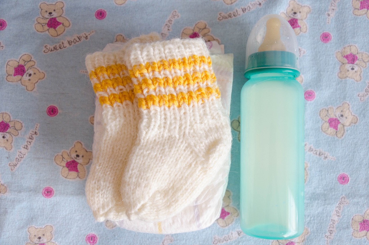 Babyschuhe und eine Flasche | Quelle: Pixabay