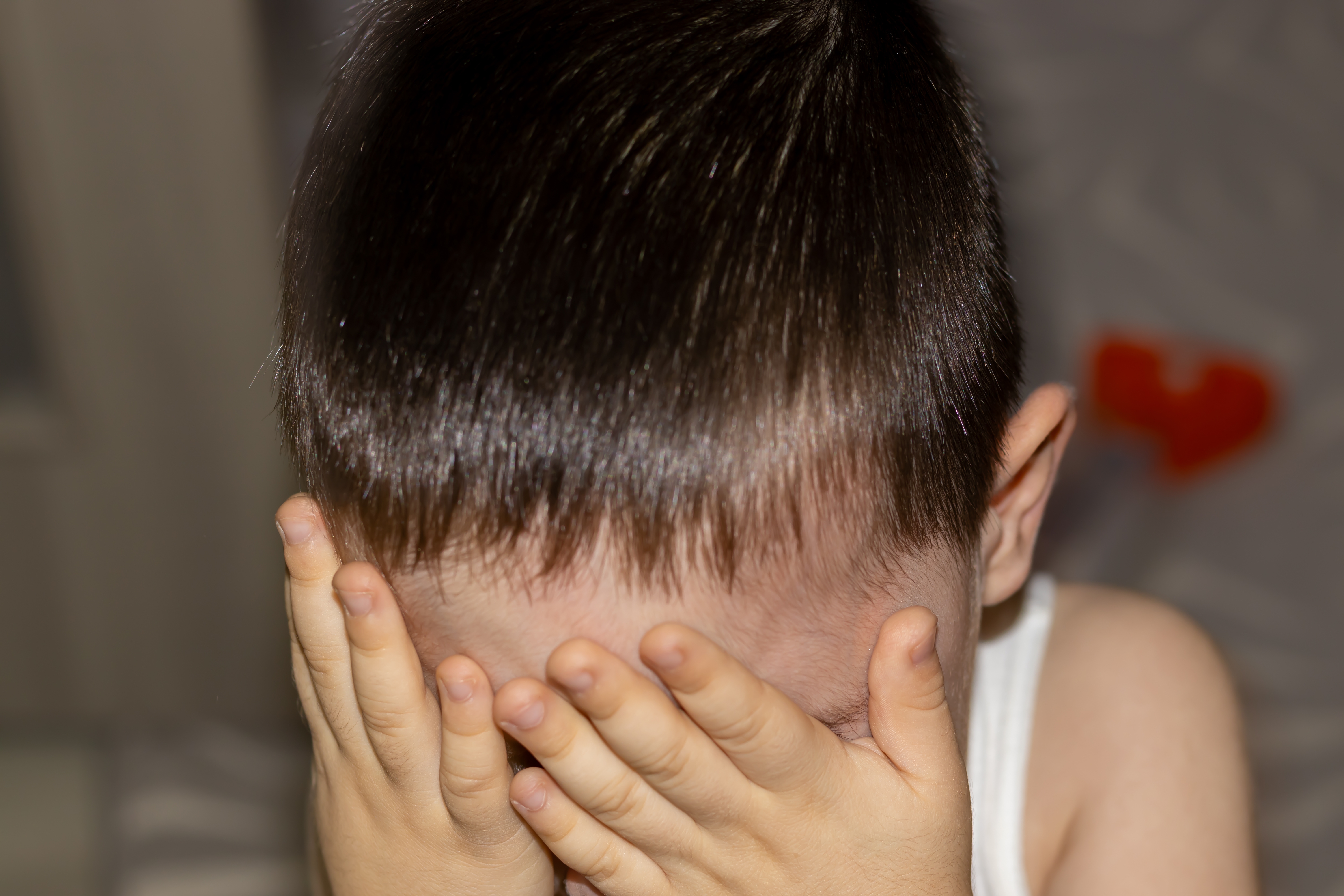 Ein Kind, das sein Gesicht versteckt | Quelle: Shutterstock