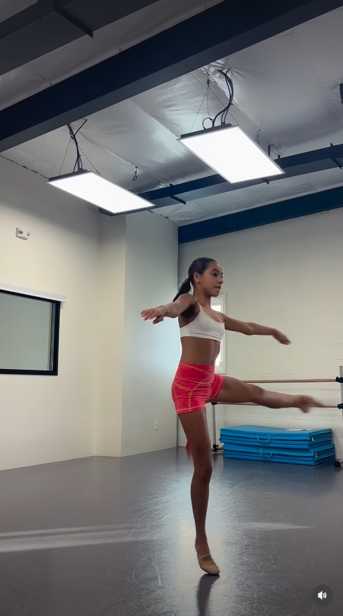 Fiona Lowe trainiert Ballett in einem Tanzstudio und balanciert auf einem Fuß, während sie bei einer Choreografie ihr Bein ausstreckt. Das Bild zeigt, wie sehr sich die Teenagerin dem Tanz verschrieben hat – eine Leidenschaft, die auch in den Monaten vor ihrem Tod noch Teil ihres Lebens war. | Quelle: Instagram/fiona.lowe.dances