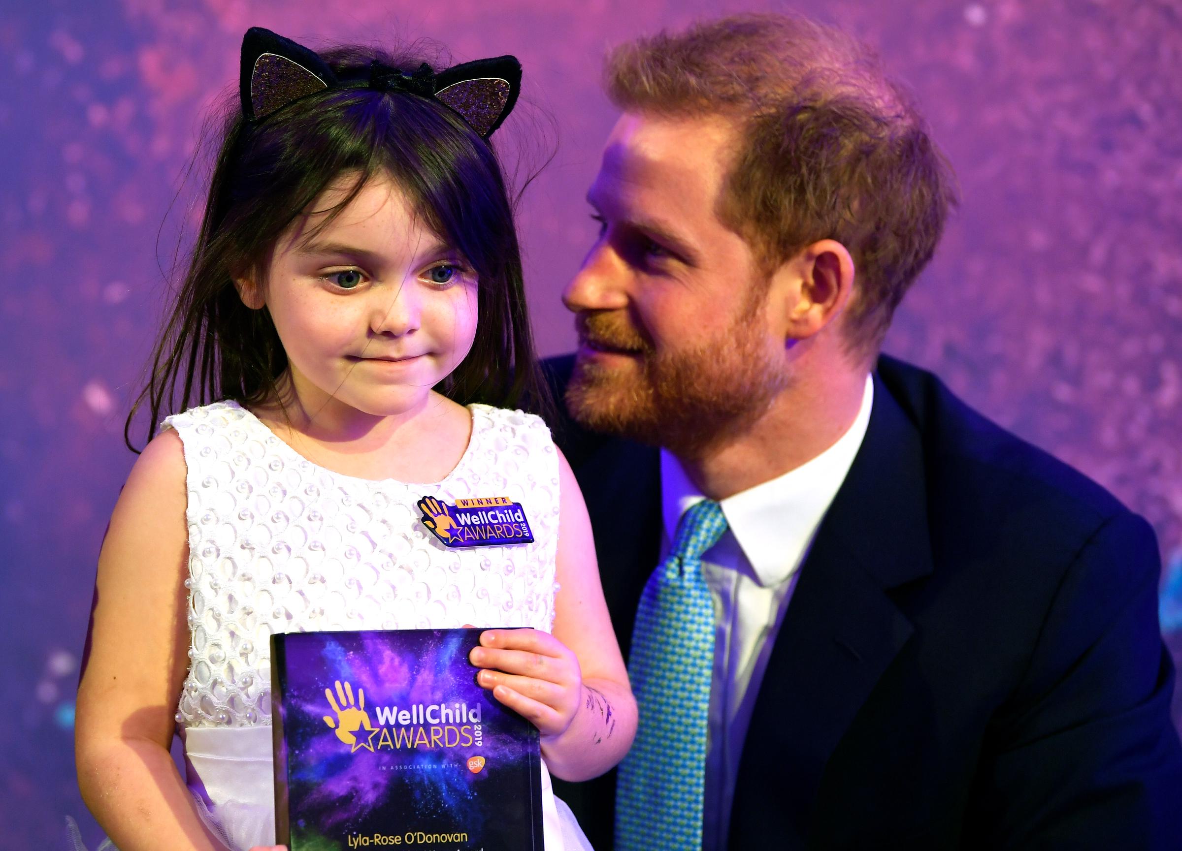 Prinz Harry mit einem kleinen Mädchen bei einer Veranstaltung der WellChild Awards in London, England am 15. Oktober 2019. | Quelle: Getty Images