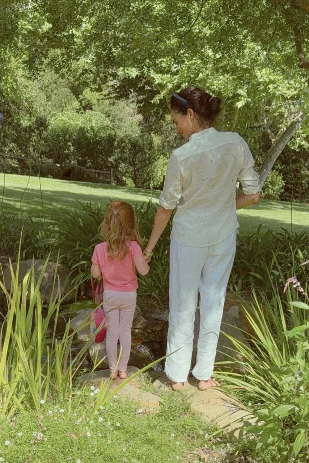 Eine Mutter und ihre Tochter halten im Garten Händchen – ein weiterer stiller Familienmoment aus ihrem Alltag, fernab von öffentlichen Veranstaltungen und Kameras. | Quelle: Meghan Markles Instagram