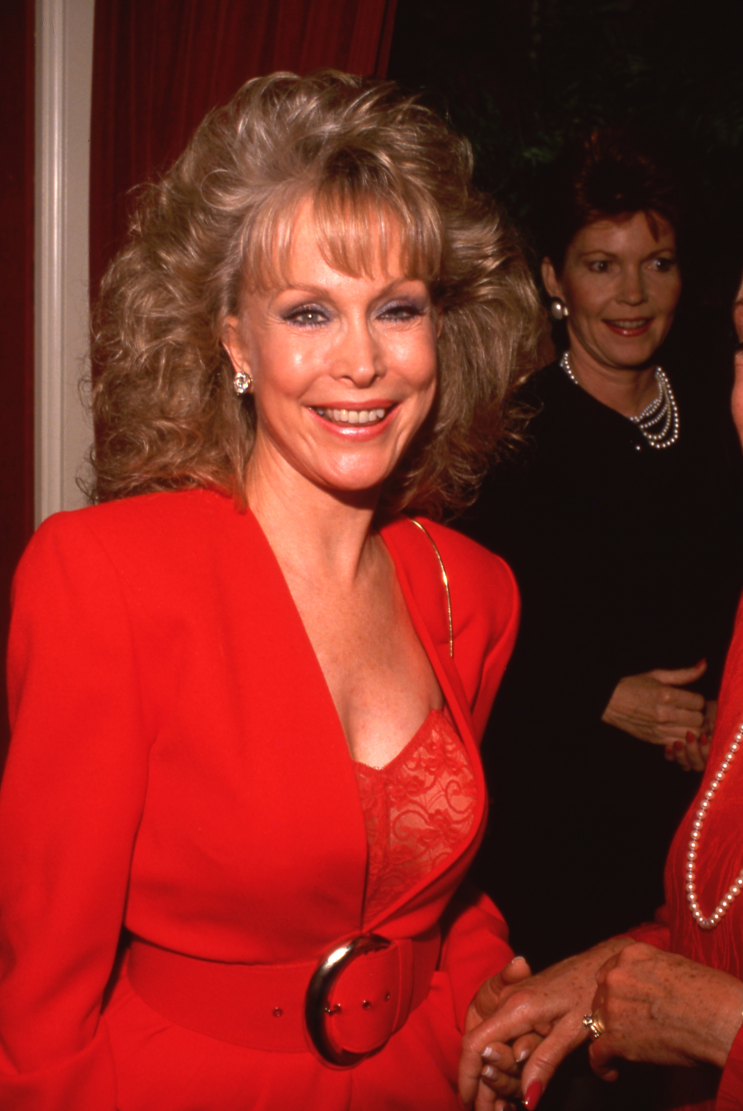 Barbara Eden trägt einen roten Anzug mit einem Spitzenoberteil, als sie 1980 eine Party besucht. | Quelle: Getty Images