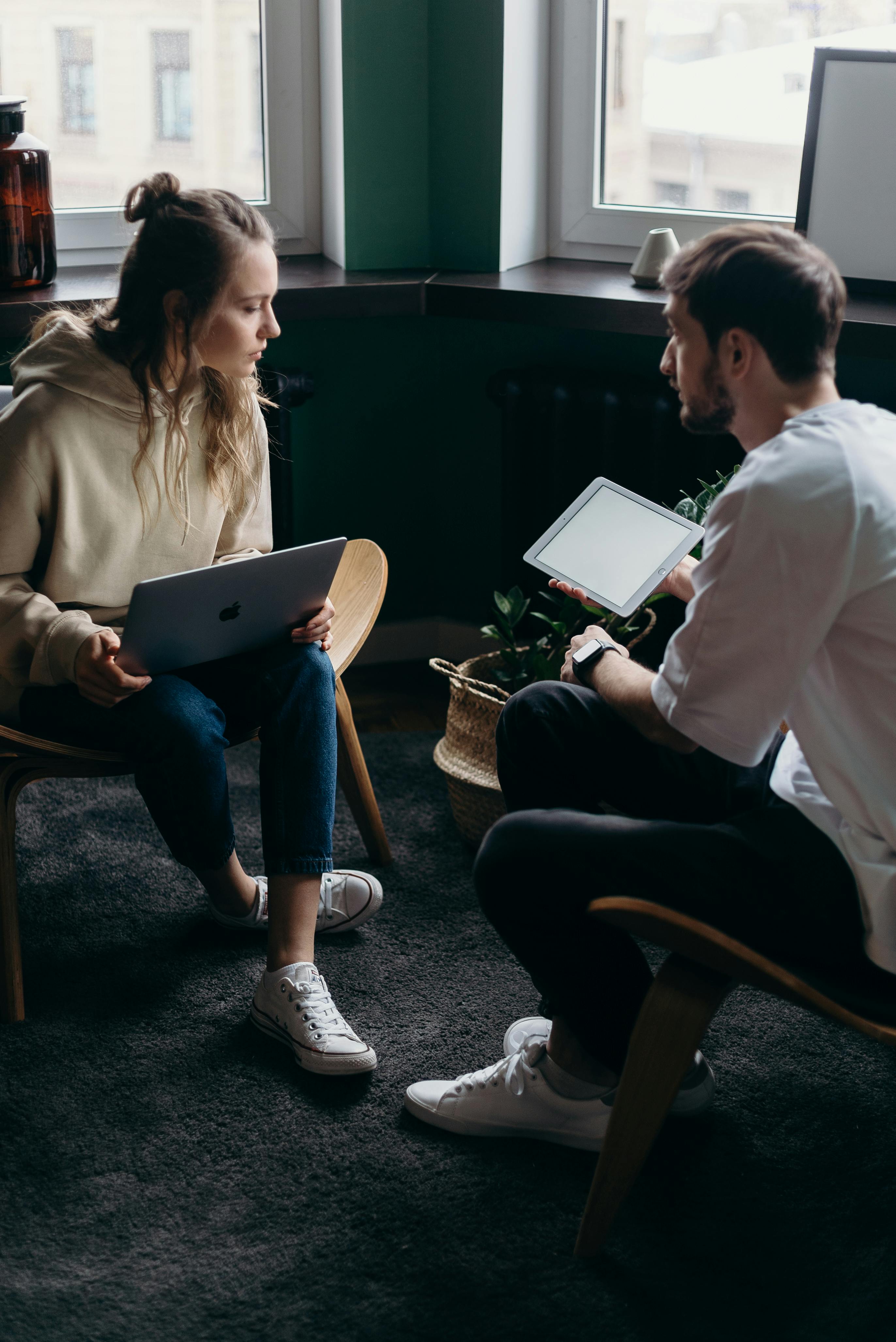 Ein Mann und eine Frau mit einem Laptop und einem Tablet | Quelle: Pexels