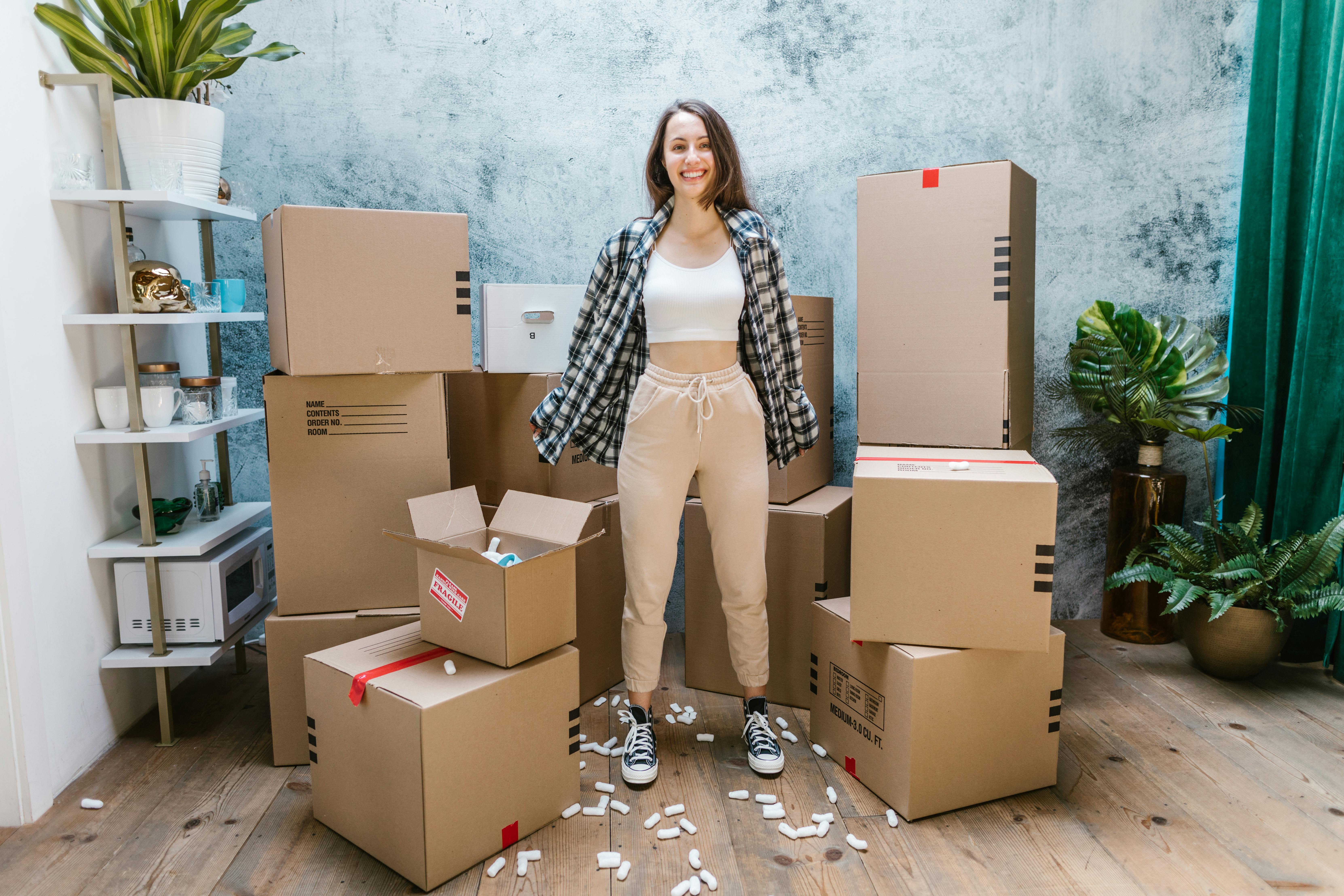 Eine Frau lächelt, während sie von Kisten umgeben ist | Quelle: Pexels