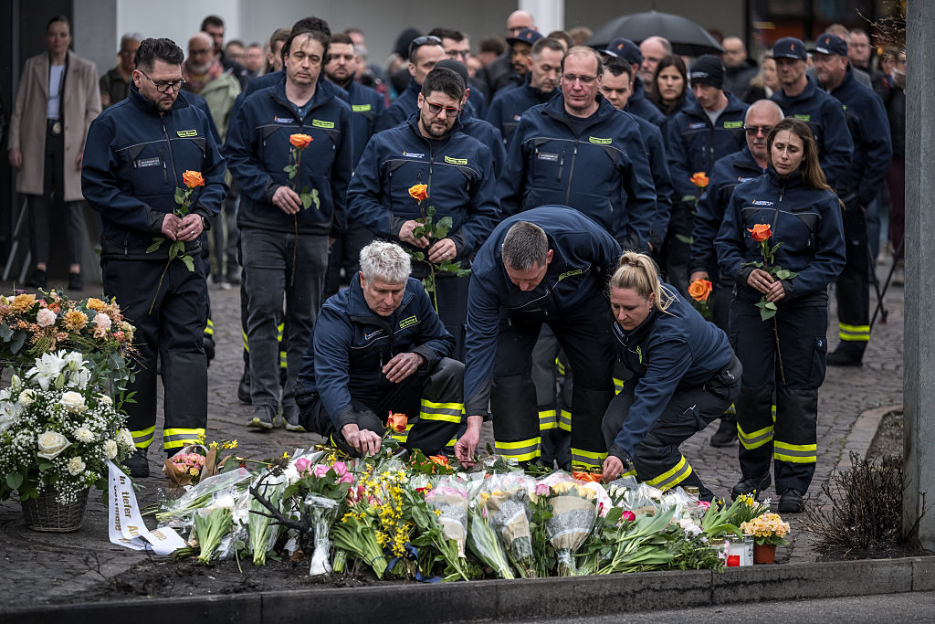 Feuerwehrleute legen Blumen nieder, um während einer Gedenkfeier in Kerzers in der Westschweiz am 11. März 2026 ihren Respekt zu zollen. Am Tag zuvor waren sechs Menschen bei einem Busbrand ums Leben gekommen, der offenbar von einem psychisch gestörten Mann an Bord ausgelöst worden war, der sich selbst in Brand gesetzt hatte | Quelle: Getty Images