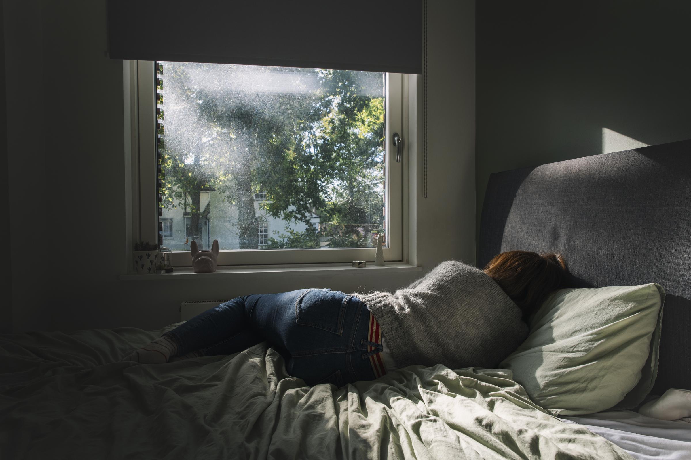 Eine Frau, die auf ihrem Bett liegt | Quelle: Getty Images