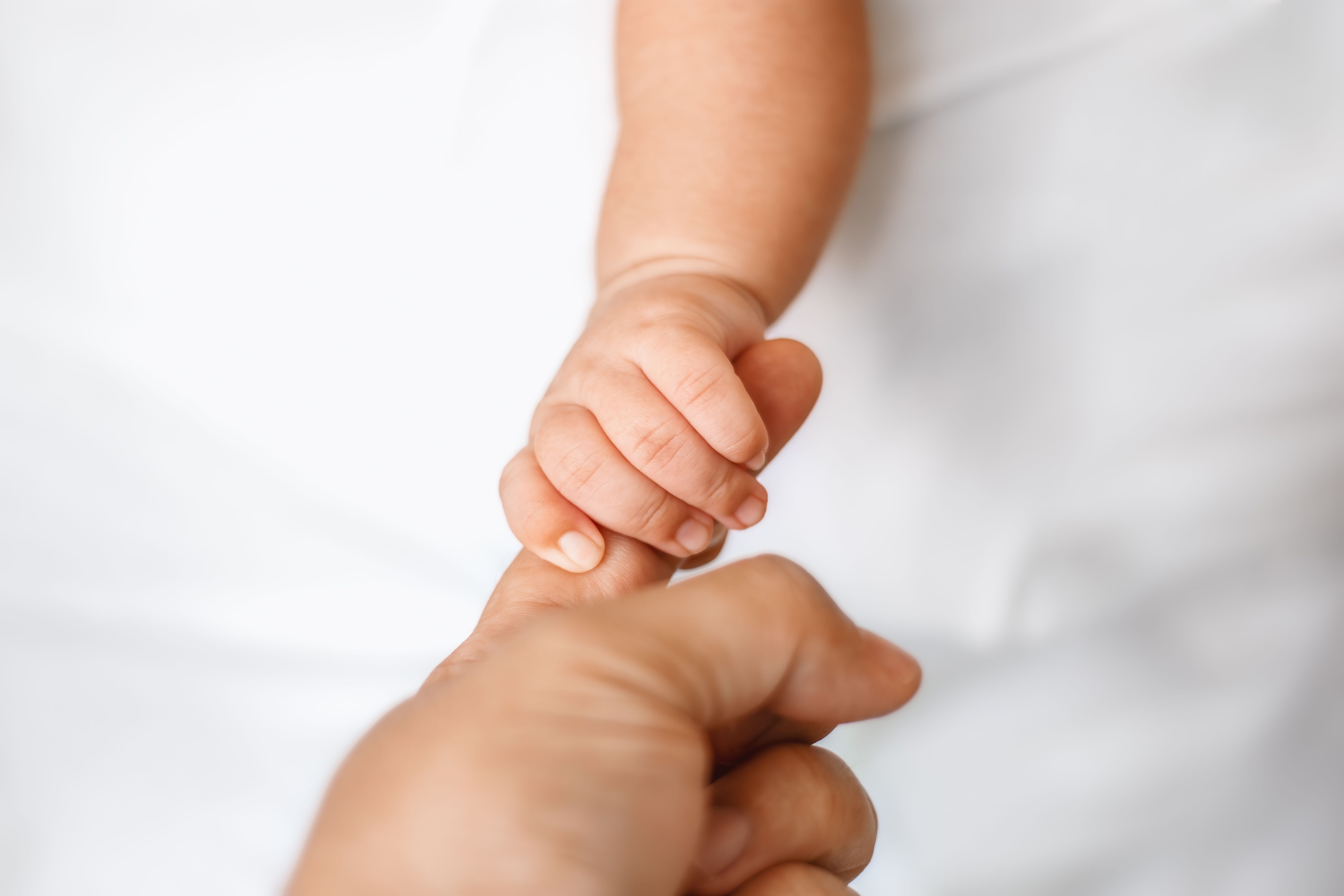 Ein Baby, das den Finger eines Erwachsenen hält | Quelle: Getty Images