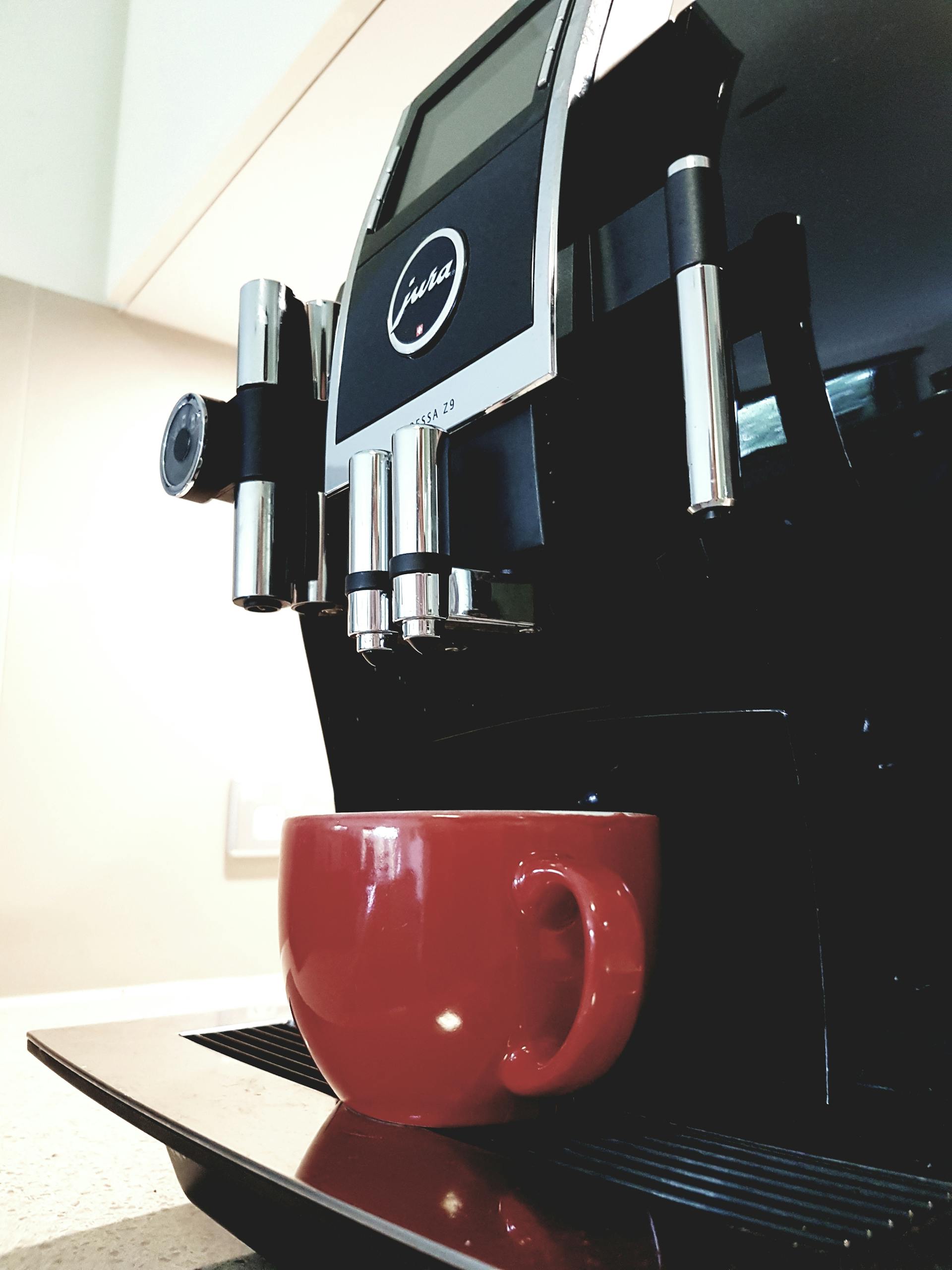 Eine Kaffeemaschine mit einer roten Tasse | Quelle: Pexels