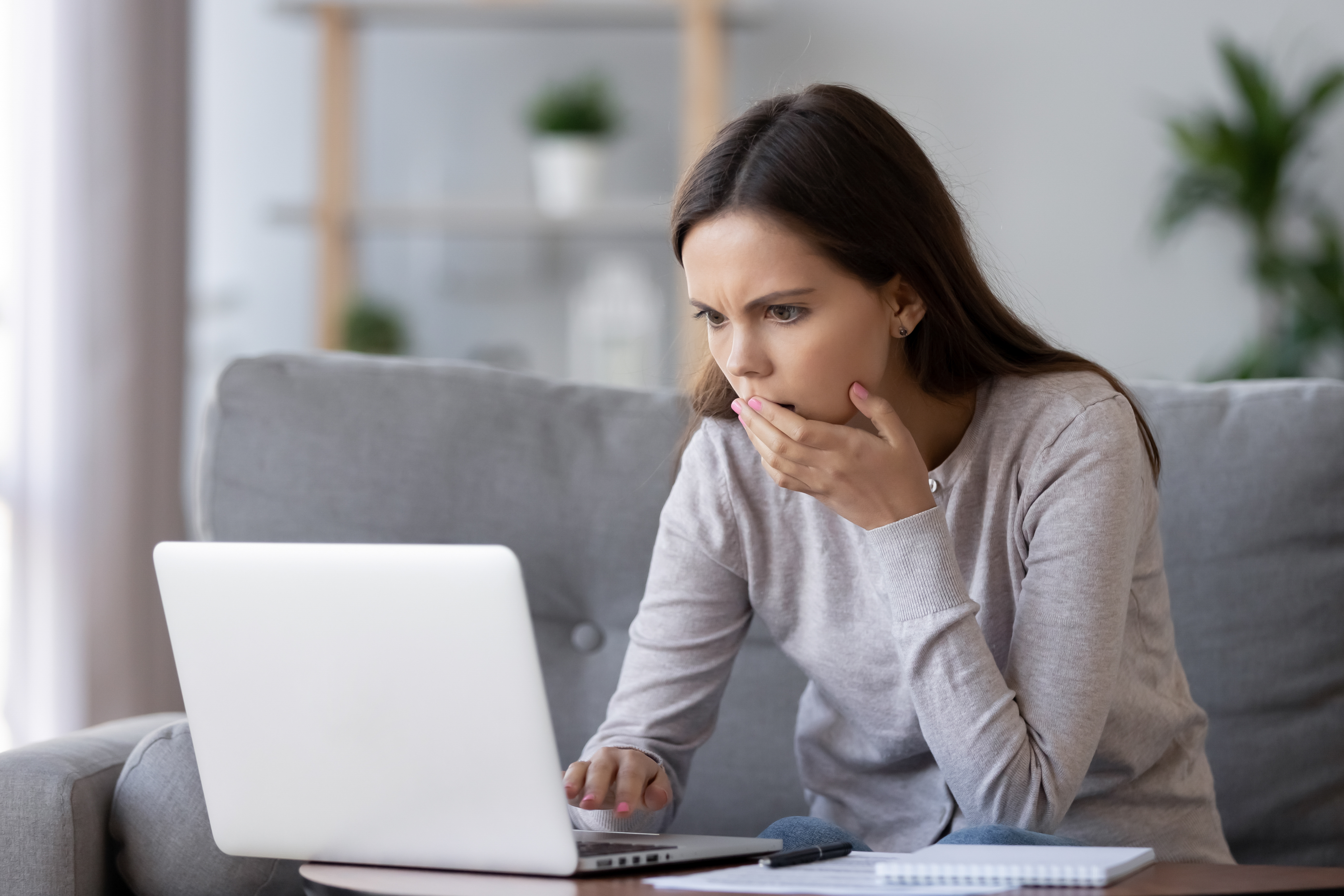 Eine Frau schockiert, nachdem sie etwas auf ihrem Laptop gesehen hat | Quelle: Shutterstock