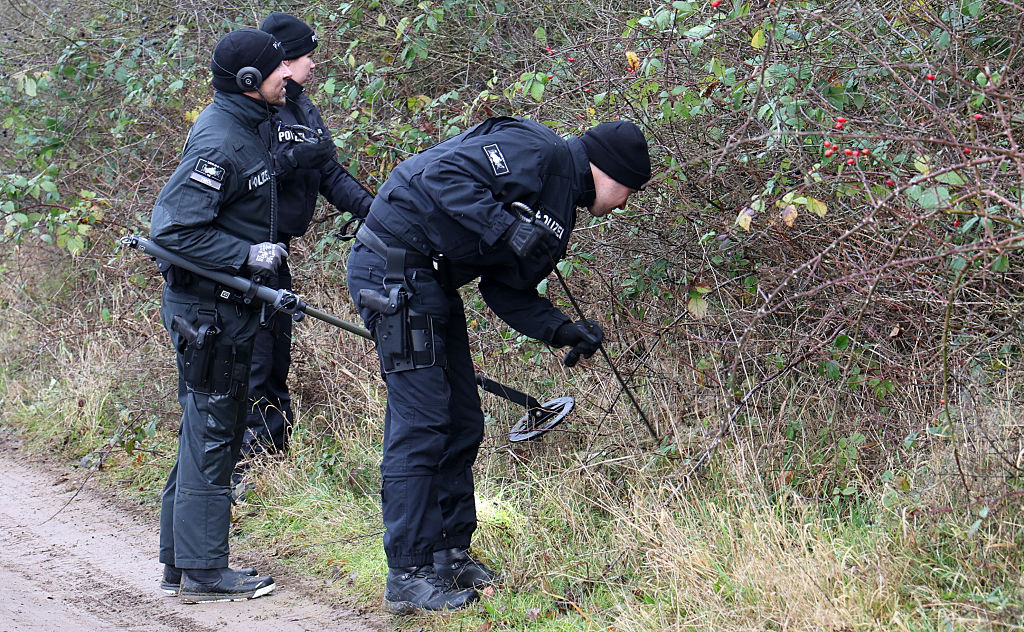 4. Dezember 2025, Mecklenburg-Vorpommern, Klein Upahl: Ganz in der Nähe von der Stelle, wo der achtjährige Fabian aus Güstrow gefunden wurde, suchen Polizisten im Gebüsch am Straßenrand. | Quelle: Getty Images