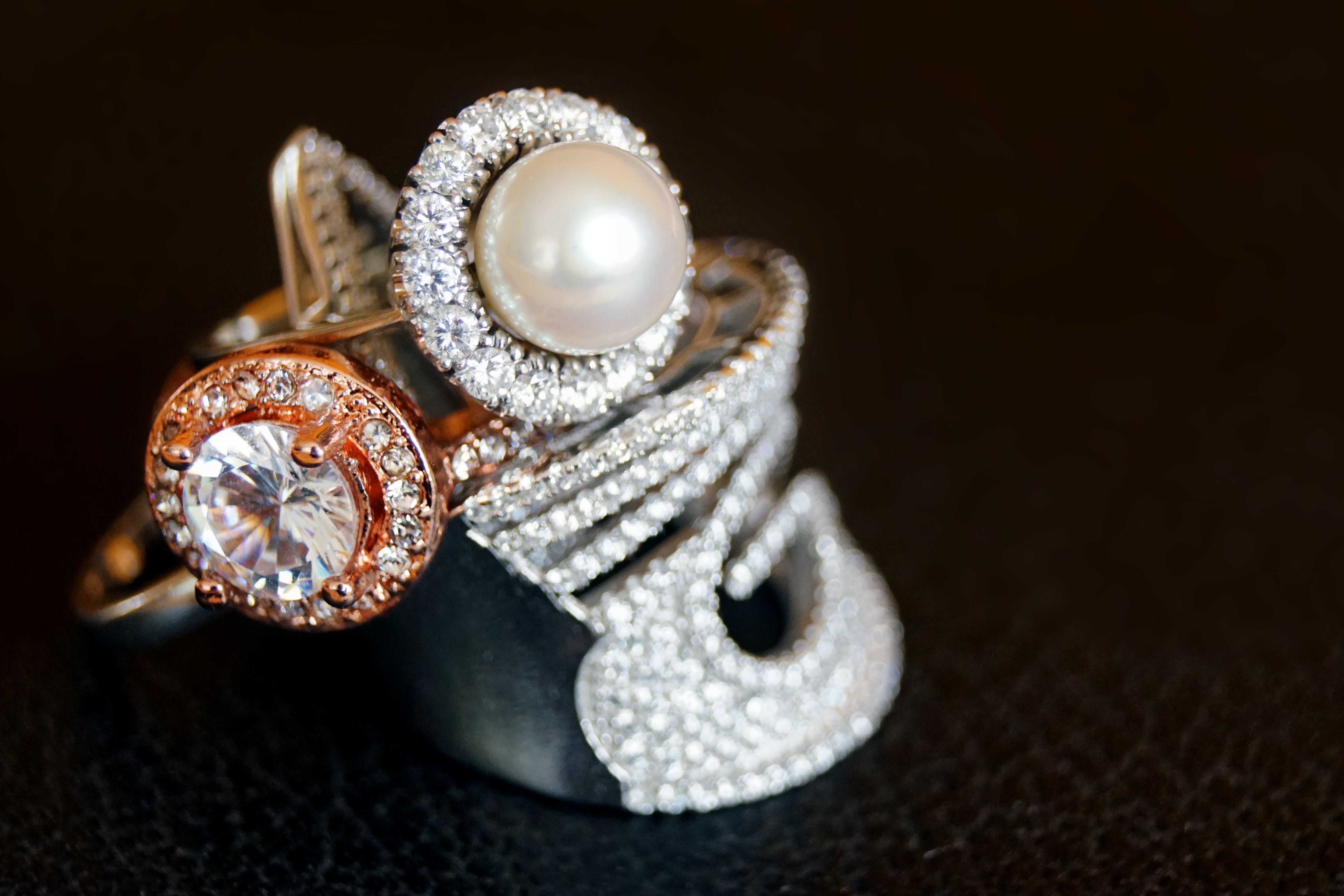 Ein silberfarbener Ring mit klarem Edelstein und weißer Perle | Quelle: Pexels
