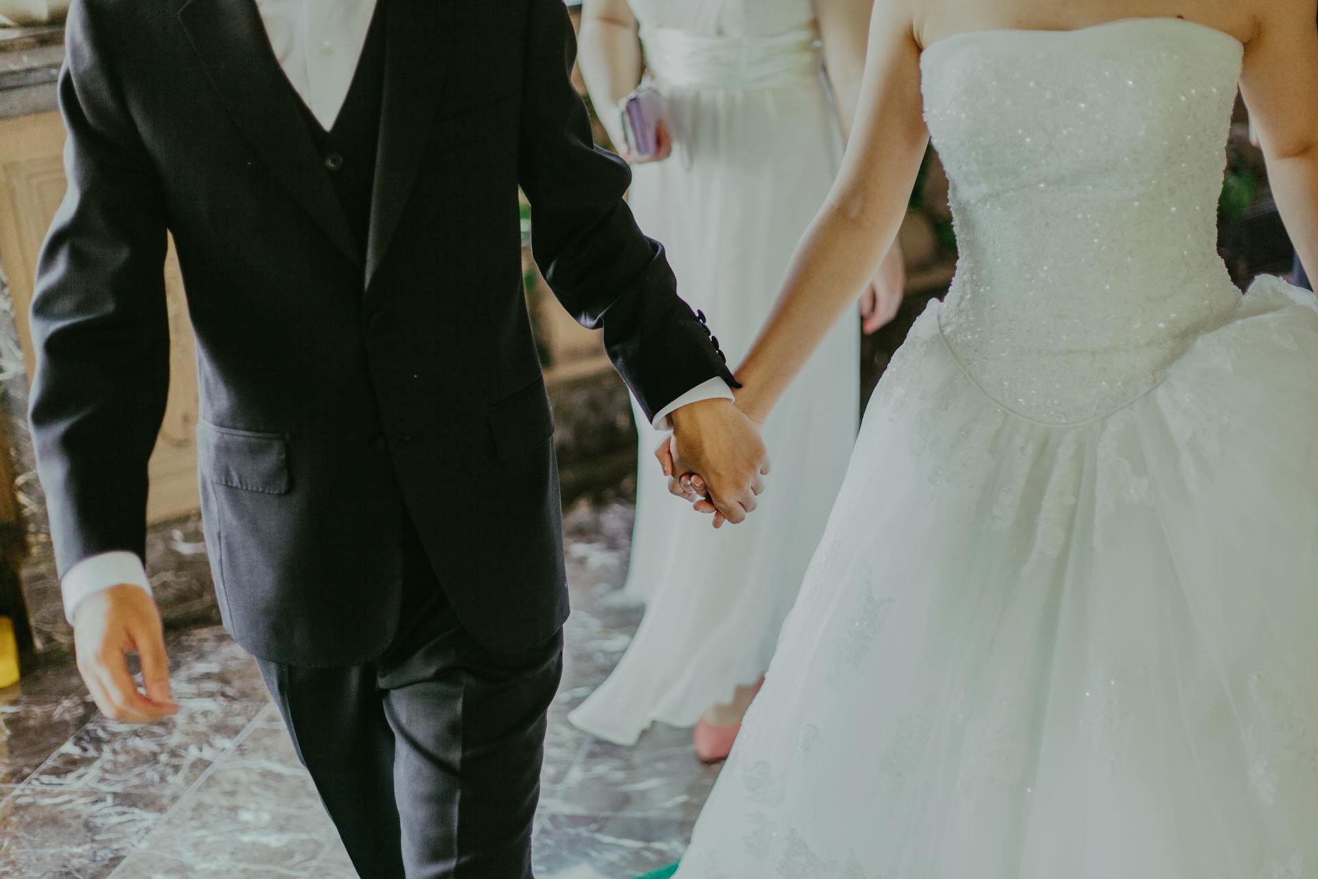 Ein Brautpaar, das sich an den Händen hält | Quelle: Pexels