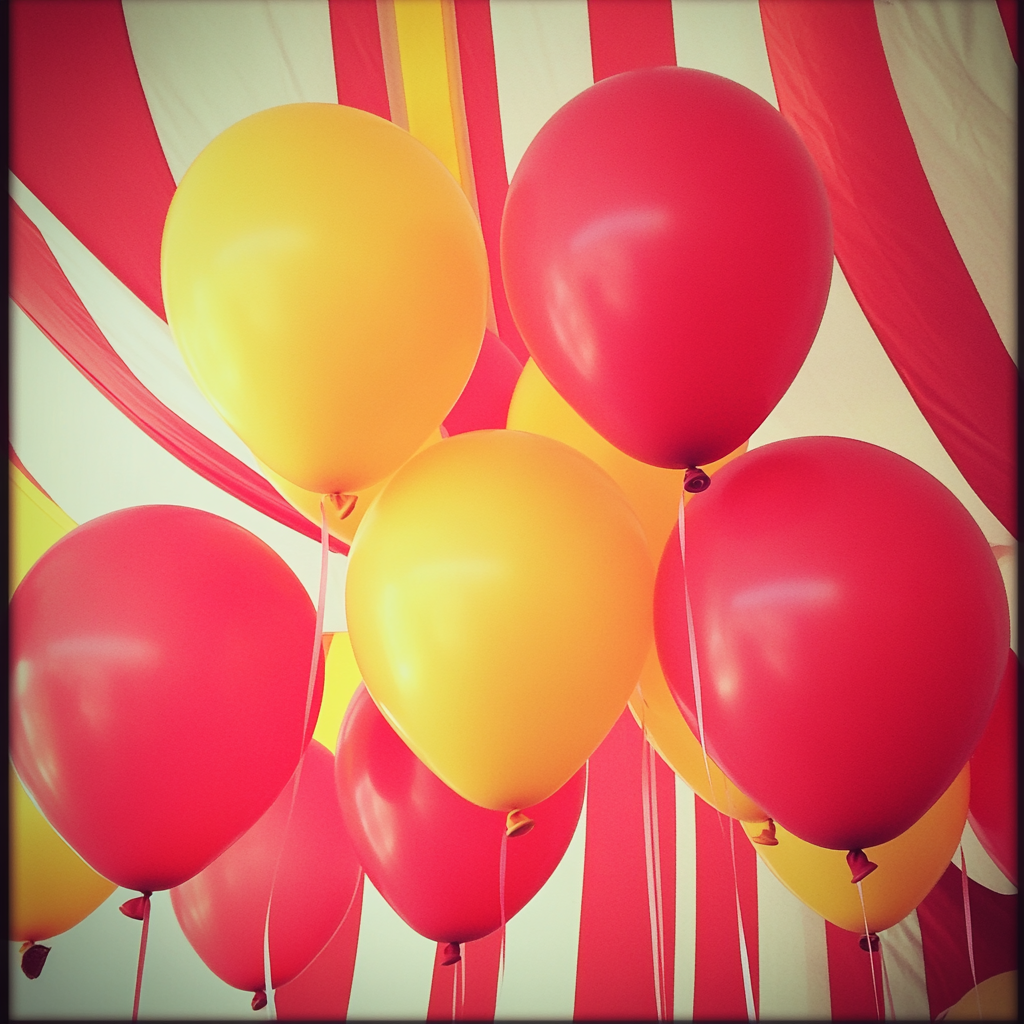 Rote und gelbe Luftballons bei einer Babyparty mit Zirkusthema | Quelle: Midjourney