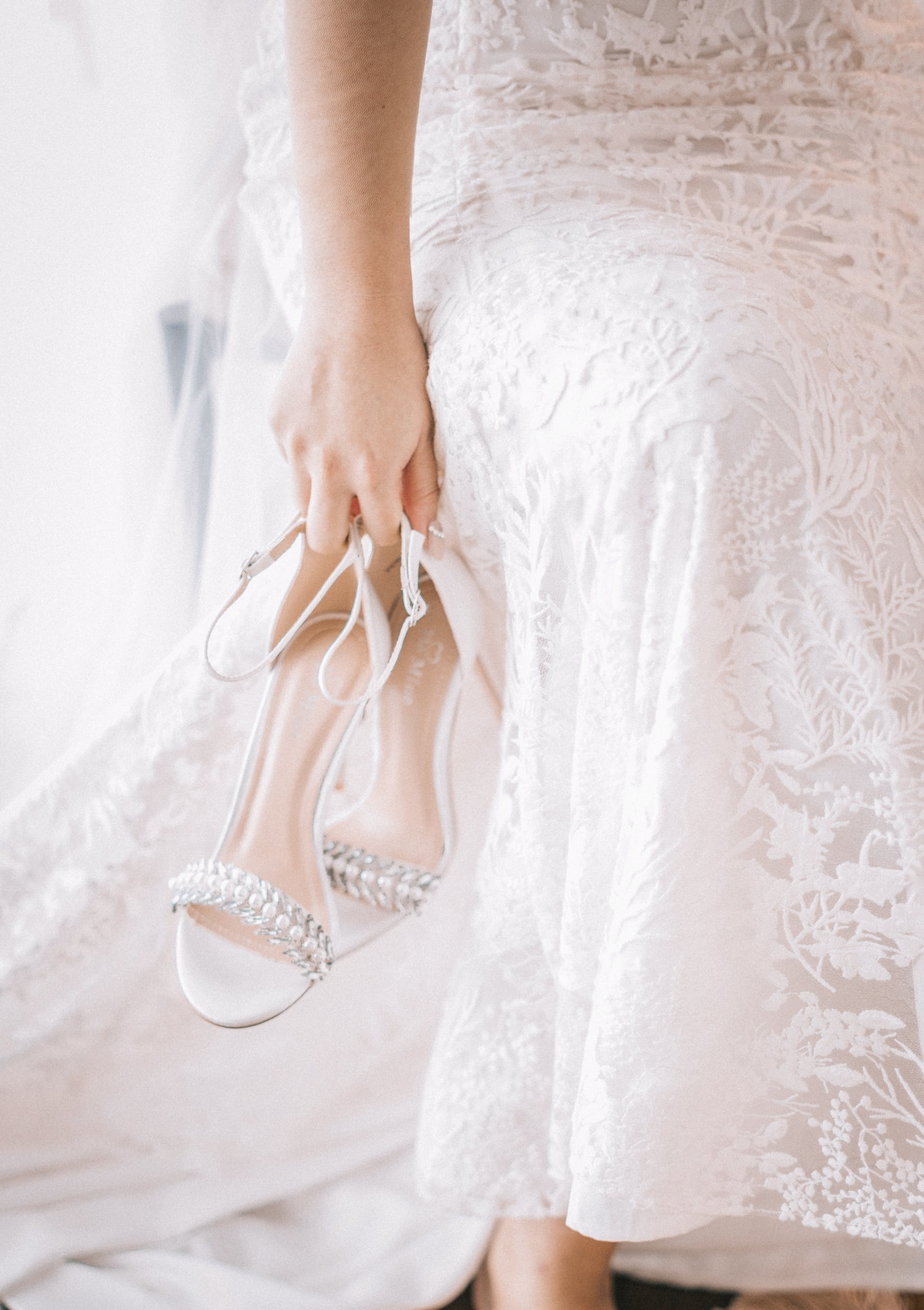 Die Braut hält ihre Schuhe | Quelle: Pexels