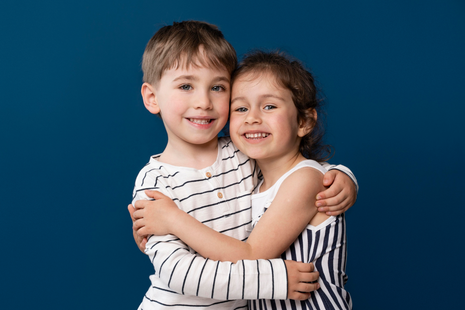 Zwei fröhliche Kinder, die sich gegenseitig umarmen | Quelle: Freepik