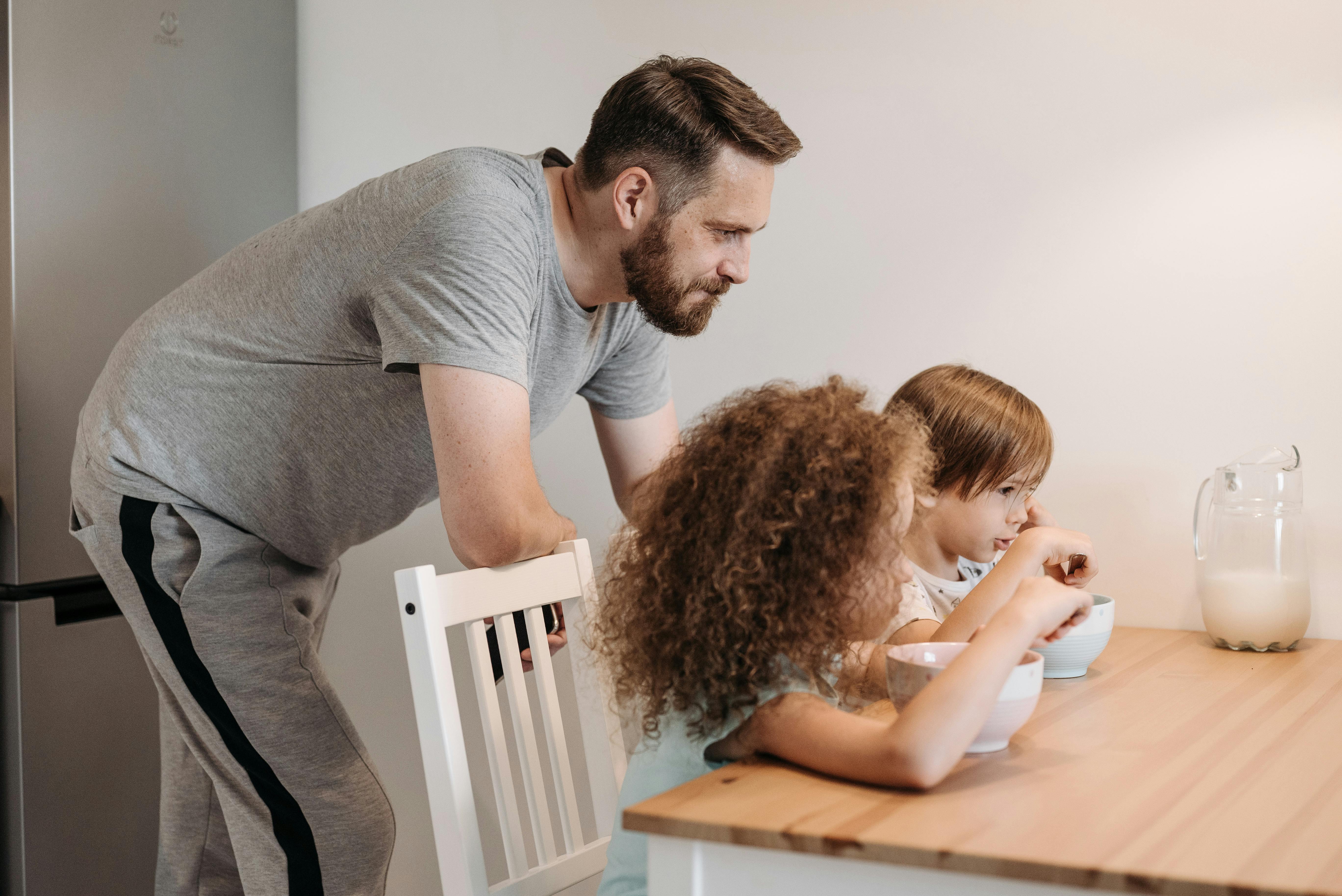 Ein Vater beobachtet seine beiden Mädchen beim Frühstück | Quelle: Pexels