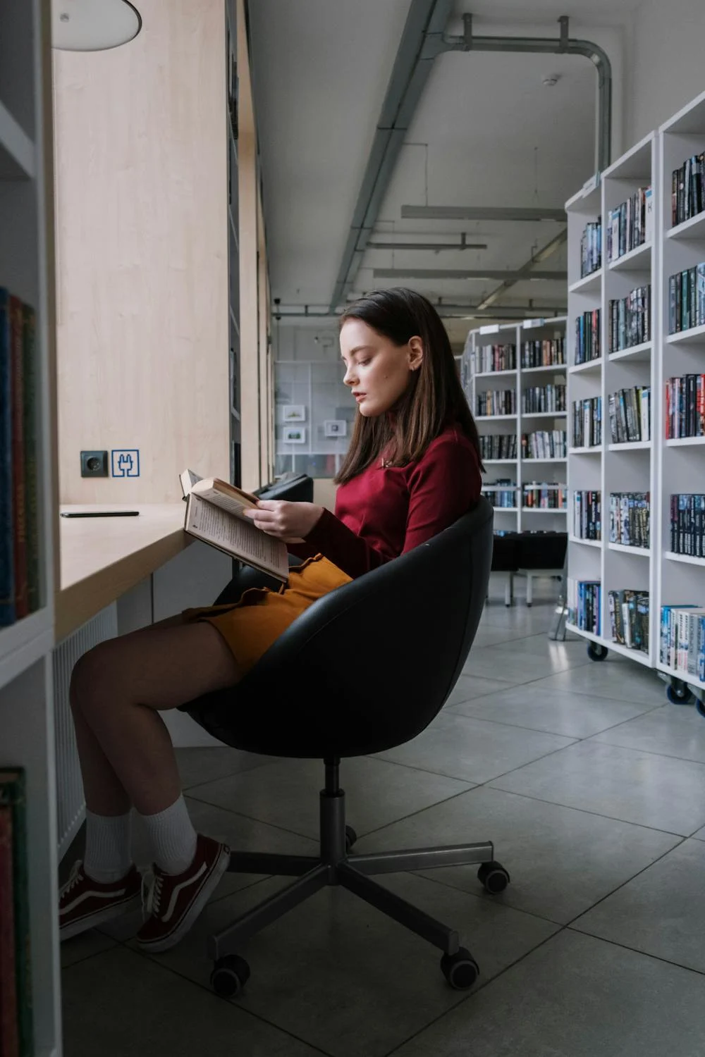 Eine Frau liest in einer Bibliothek | Quelle: Pexels