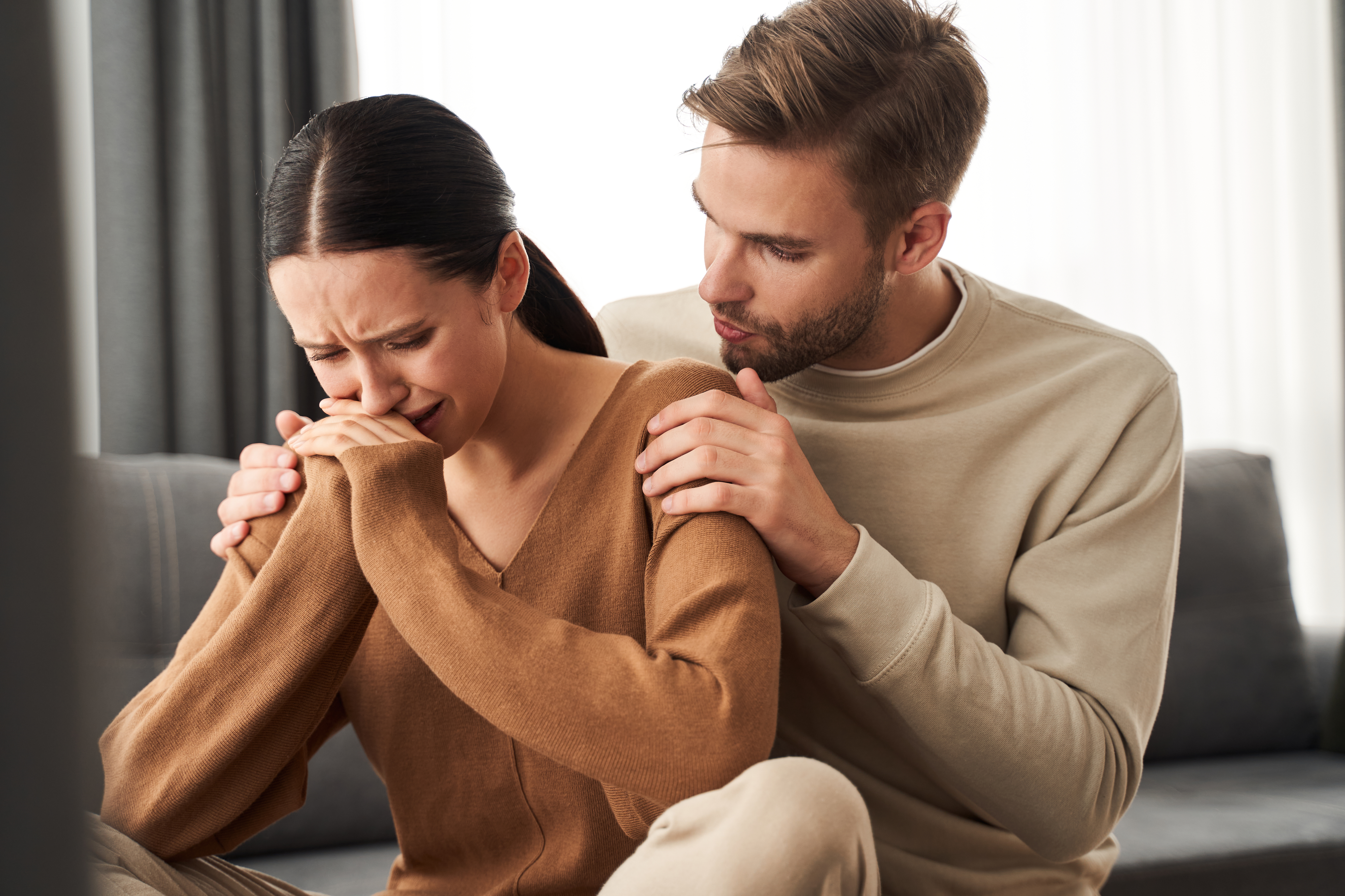 Ein Ehemann beruhigt seine weinende Frau | Quelle: Shutterstock