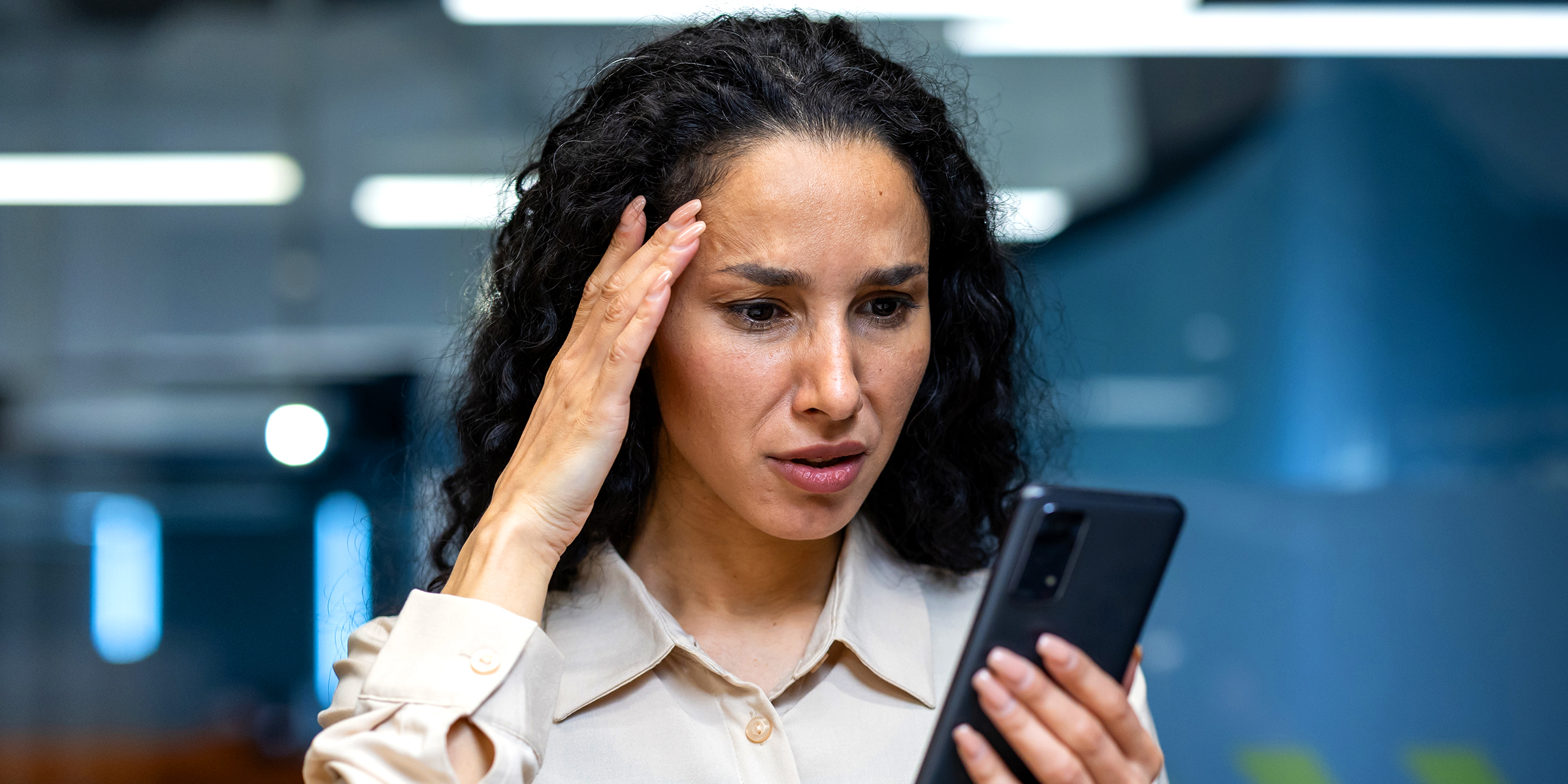 Eine Frau schaut auf ihr Telefon | Quelle: Shutterstock