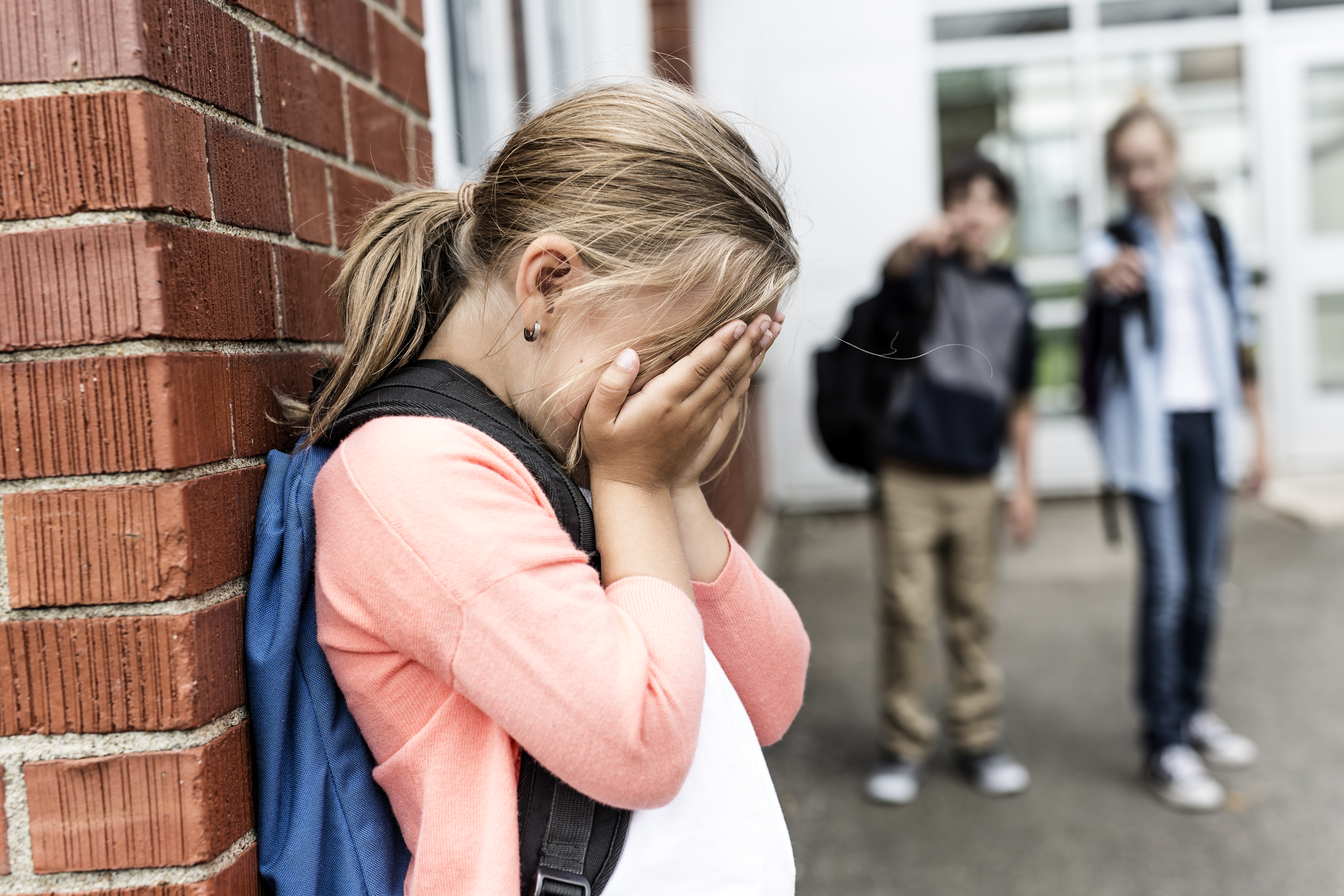 Ein weinendes Mädchen auf dem Schulflur | Quelle: Shutterstock