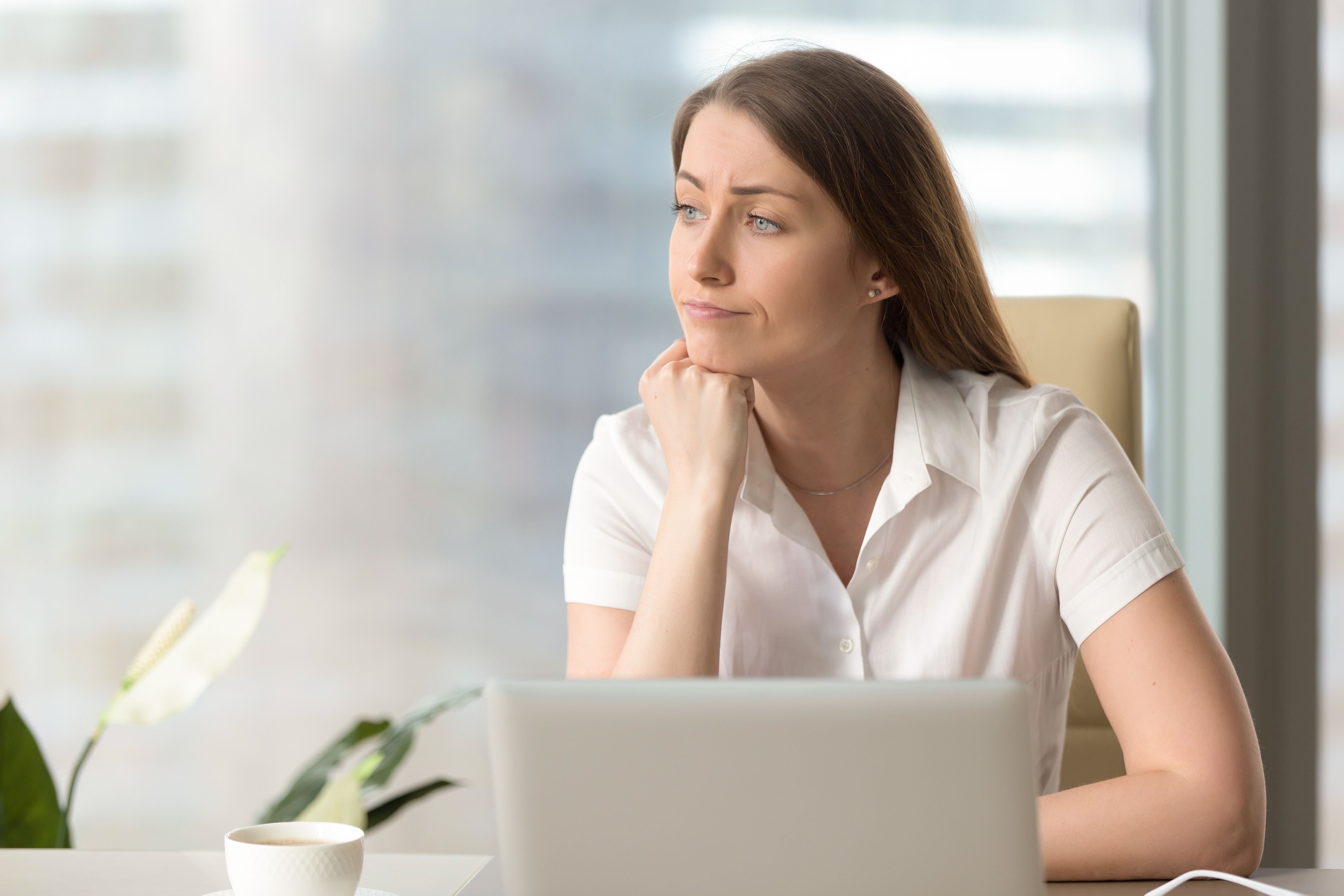 Eine Frau sieht enttäuscht aus, während sie auf einen Laptop schaut. | Quelle: Shutterstock