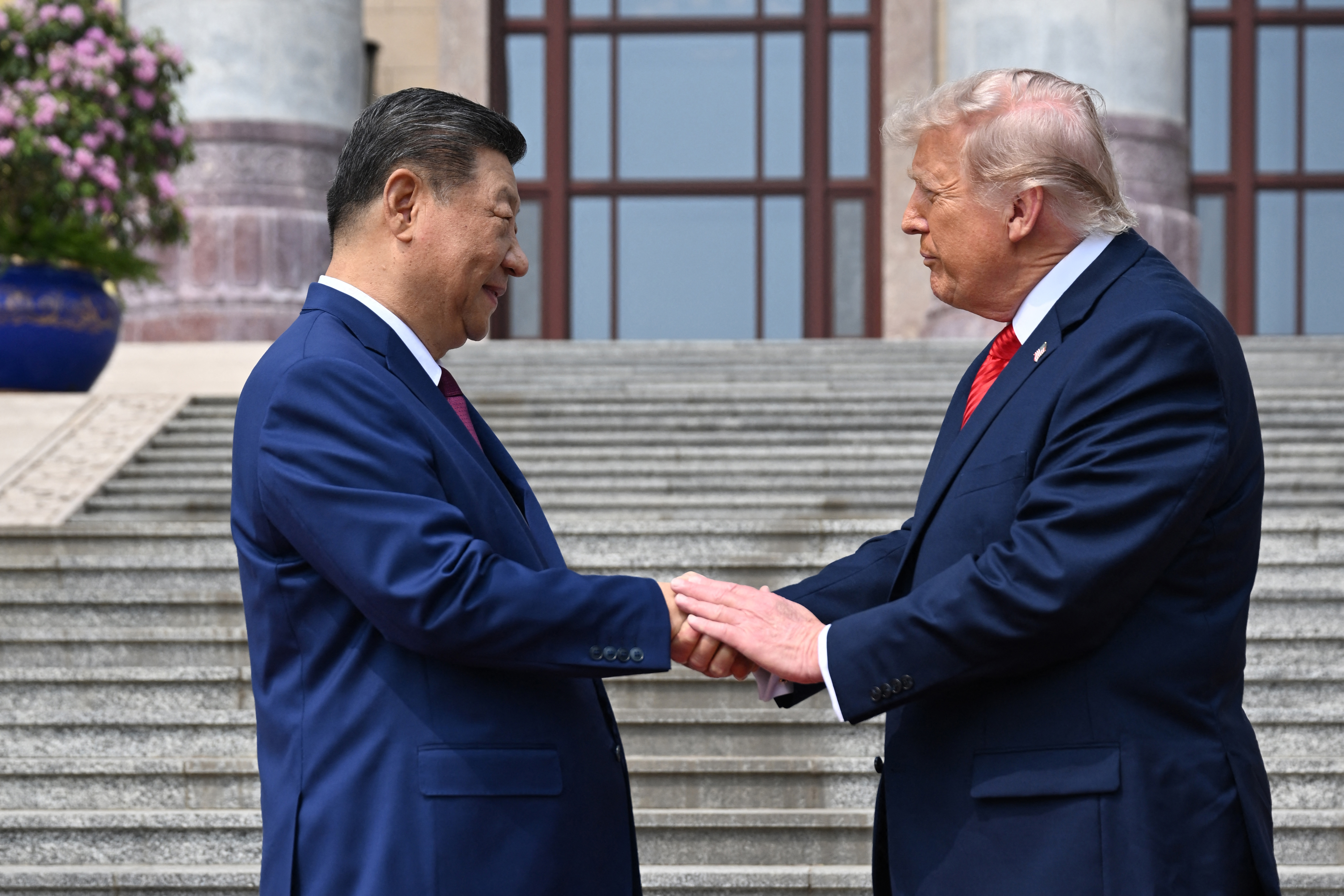 Präsident Donald Trump, mit zusammengepressten Lippen, gibt Präsident Xi Jinping am 14. Mai 2026 in der Großen Halle des Volkes in Peking die Hand. | Quelle: Getty Images