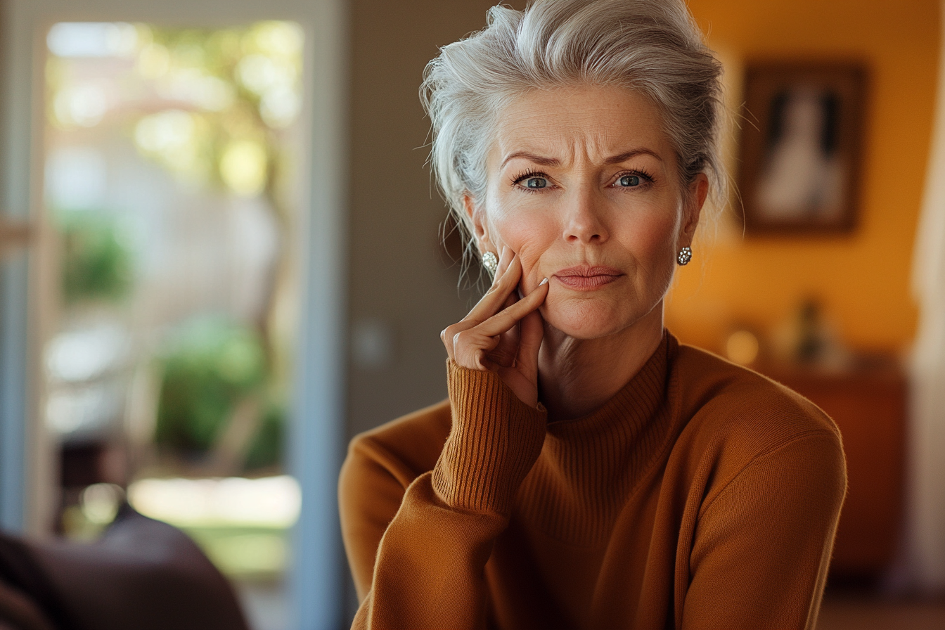 Elegante Frau in ihren 60ern, die besorgt in ihr Wohnzimmer schaut | Quelle: Midjourney