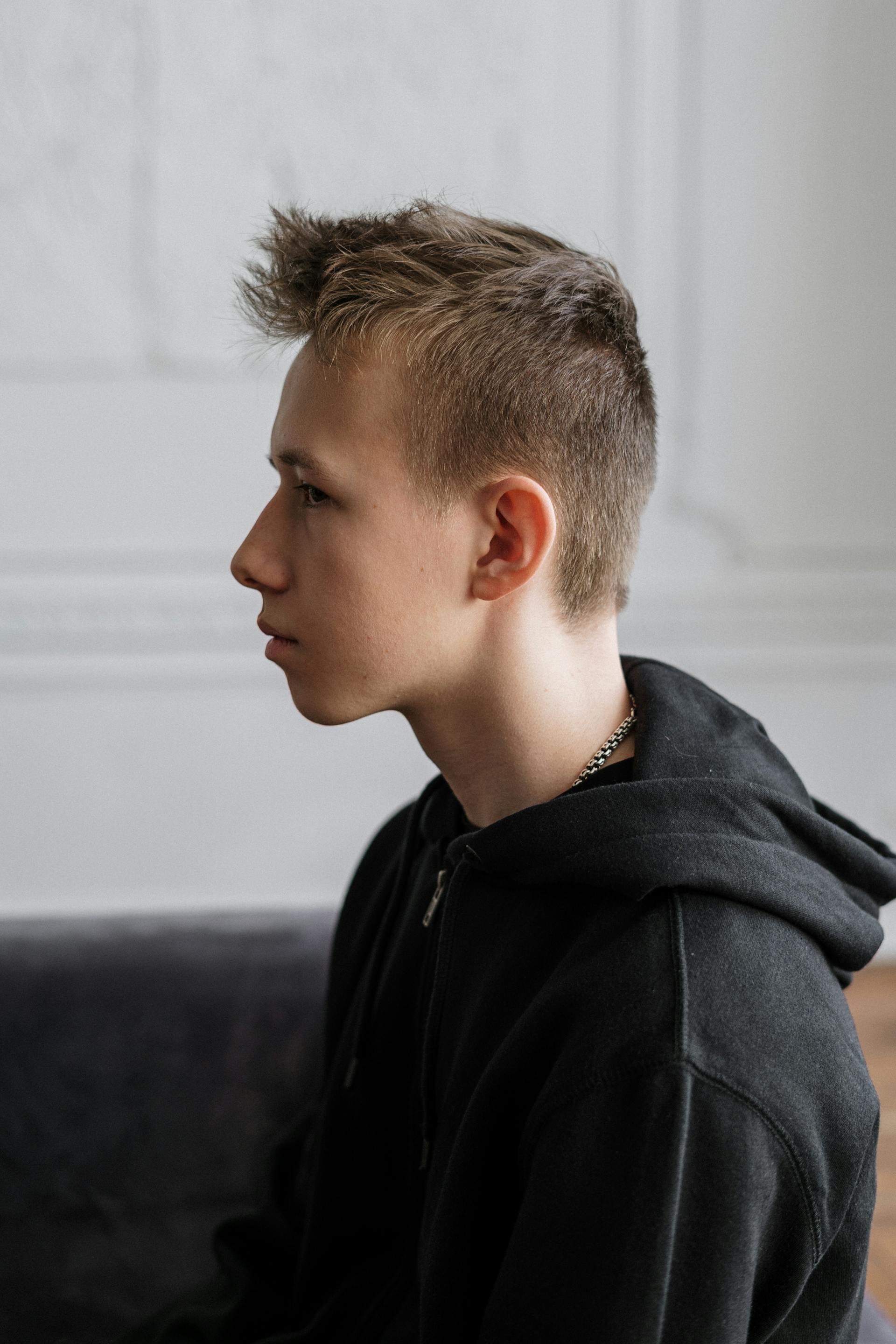 Ein nachdenklicher Teenager-Junge auf einem Sofa | Quelle: Pexels