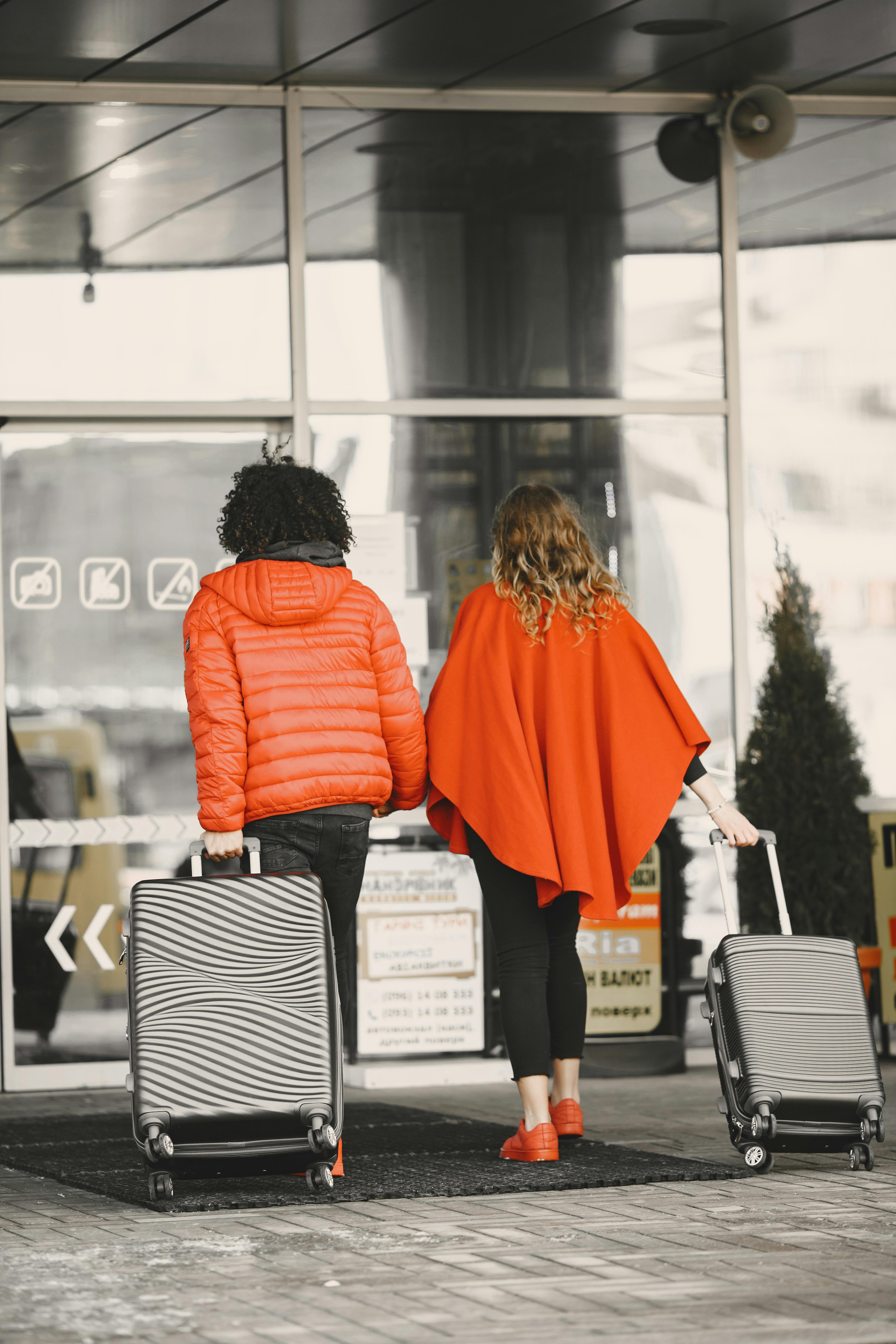 Ein Paar schleppt sein Gepäck, als es einen Flughafen betritt | Quelle: Pexels