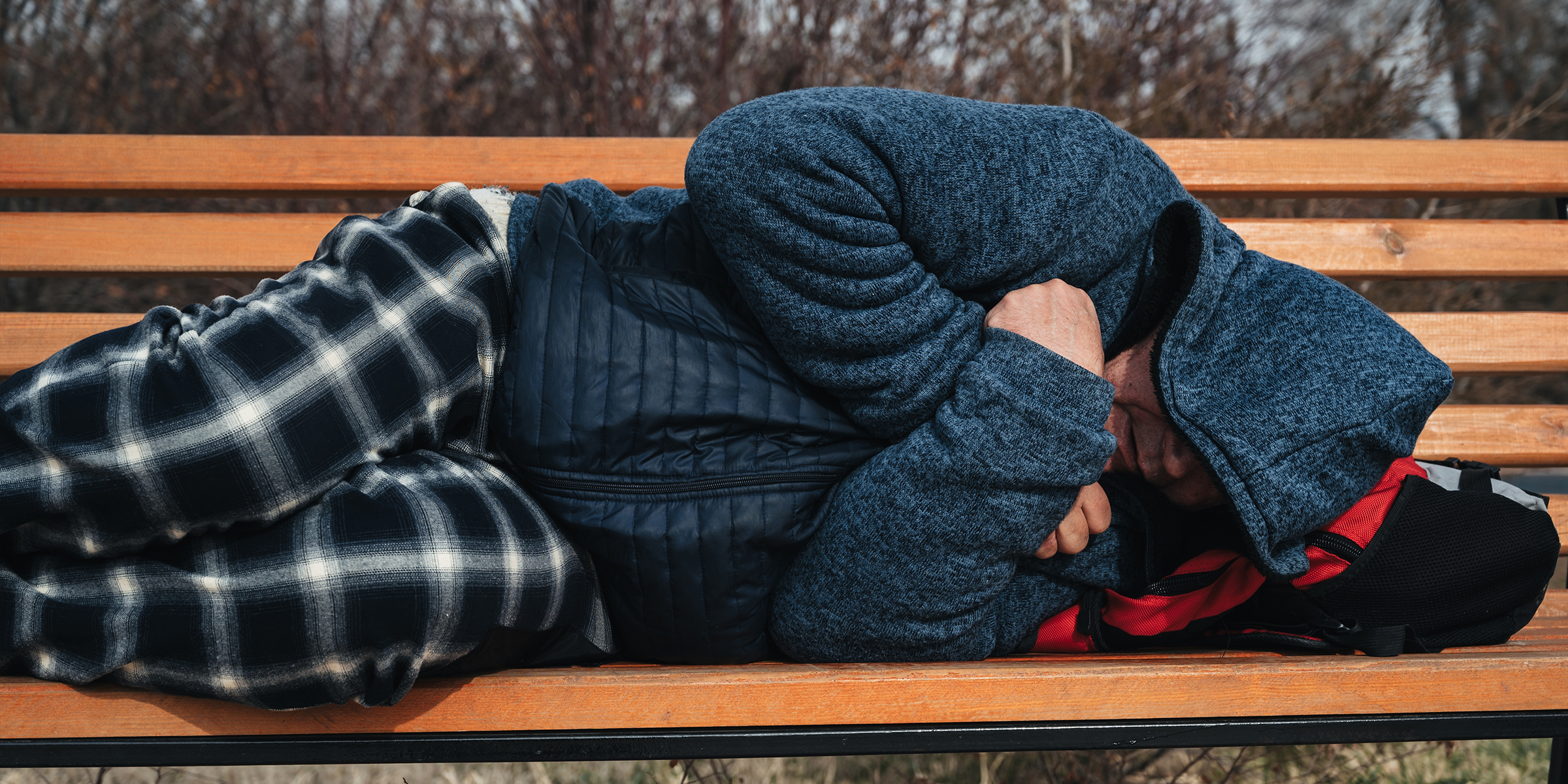 Ein Mann, der auf einer Bank schläft | Quelle: Shutterstock