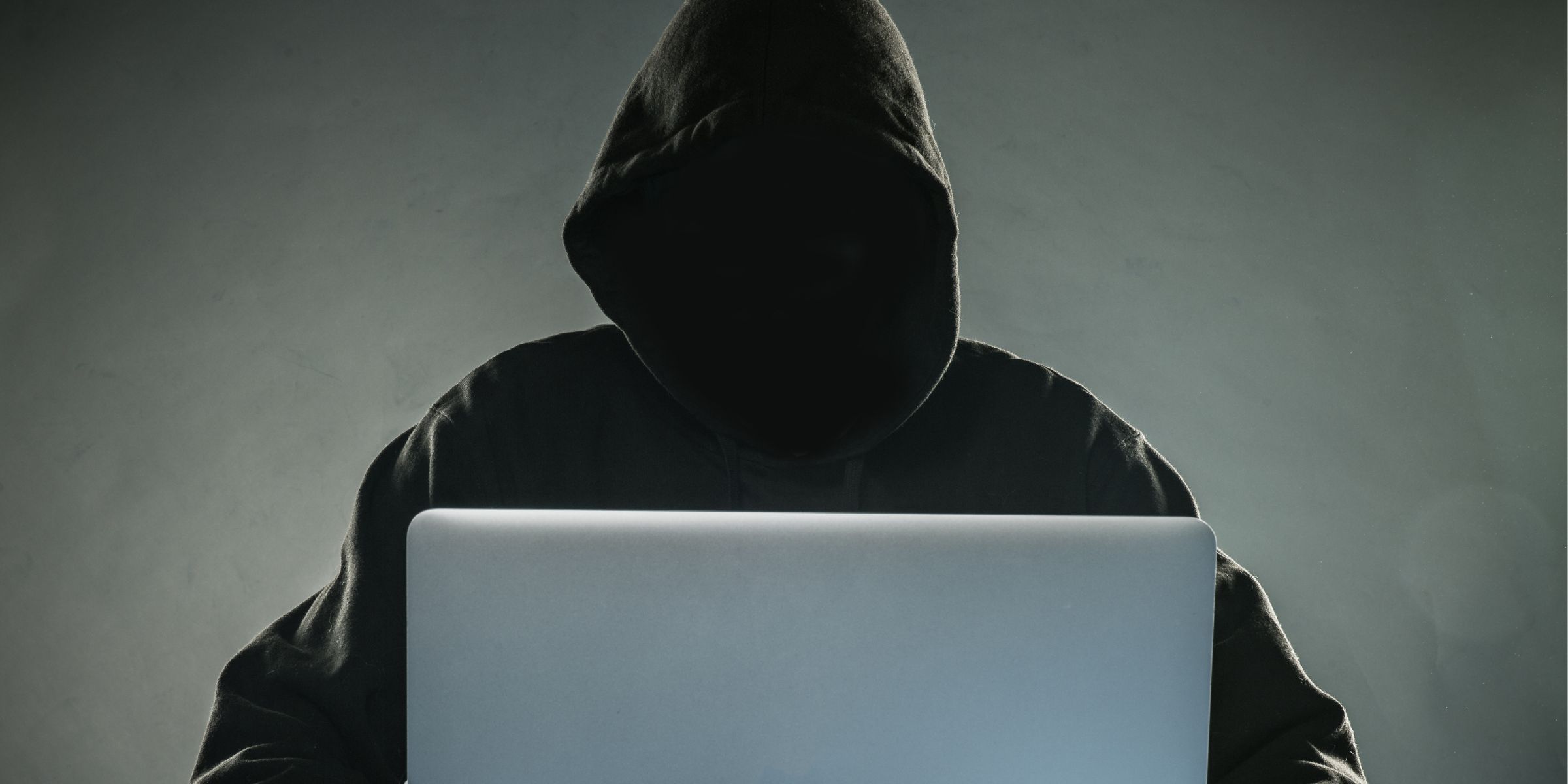 Ein Hacker in einem Kapuzenpulli mit einem Laptop | Quelle: Shutterstock