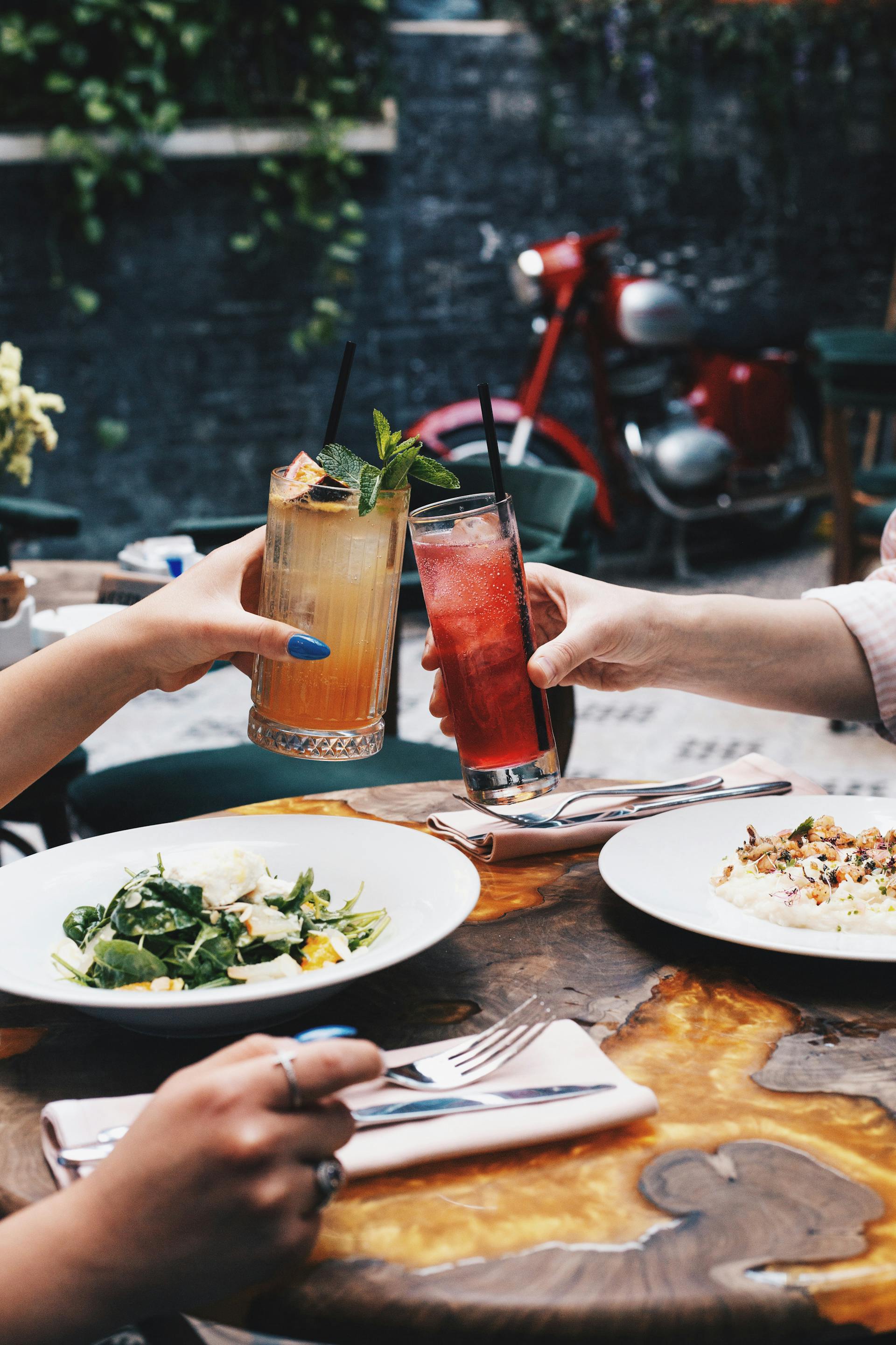 Menschen in einem Restaurant jubeln mit eisgekühlten Cocktails | Quelle: Pexels