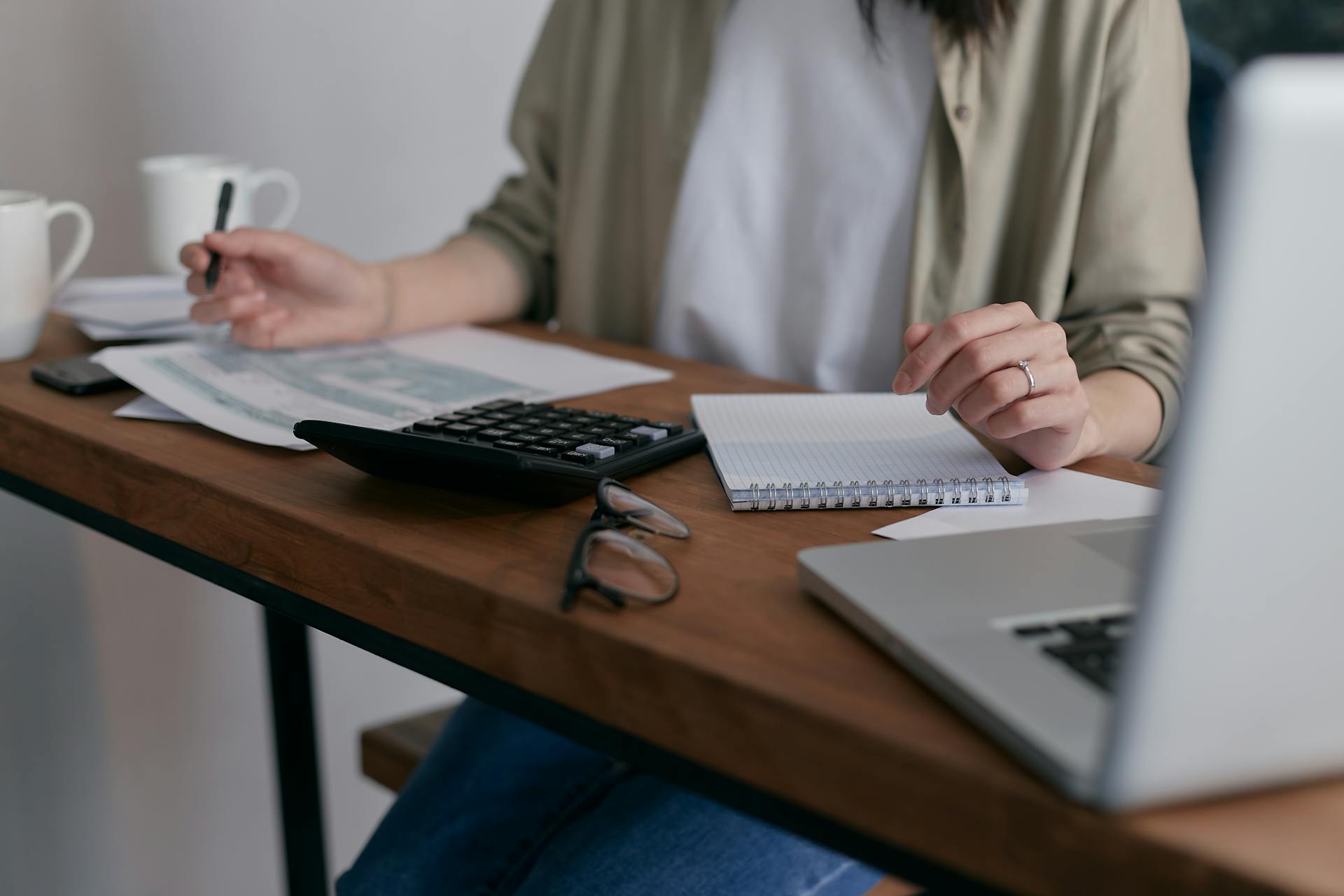 Eine Frau arbeitet mit einem Notizblock und einem Taschenrechner | Quelle: Pexels