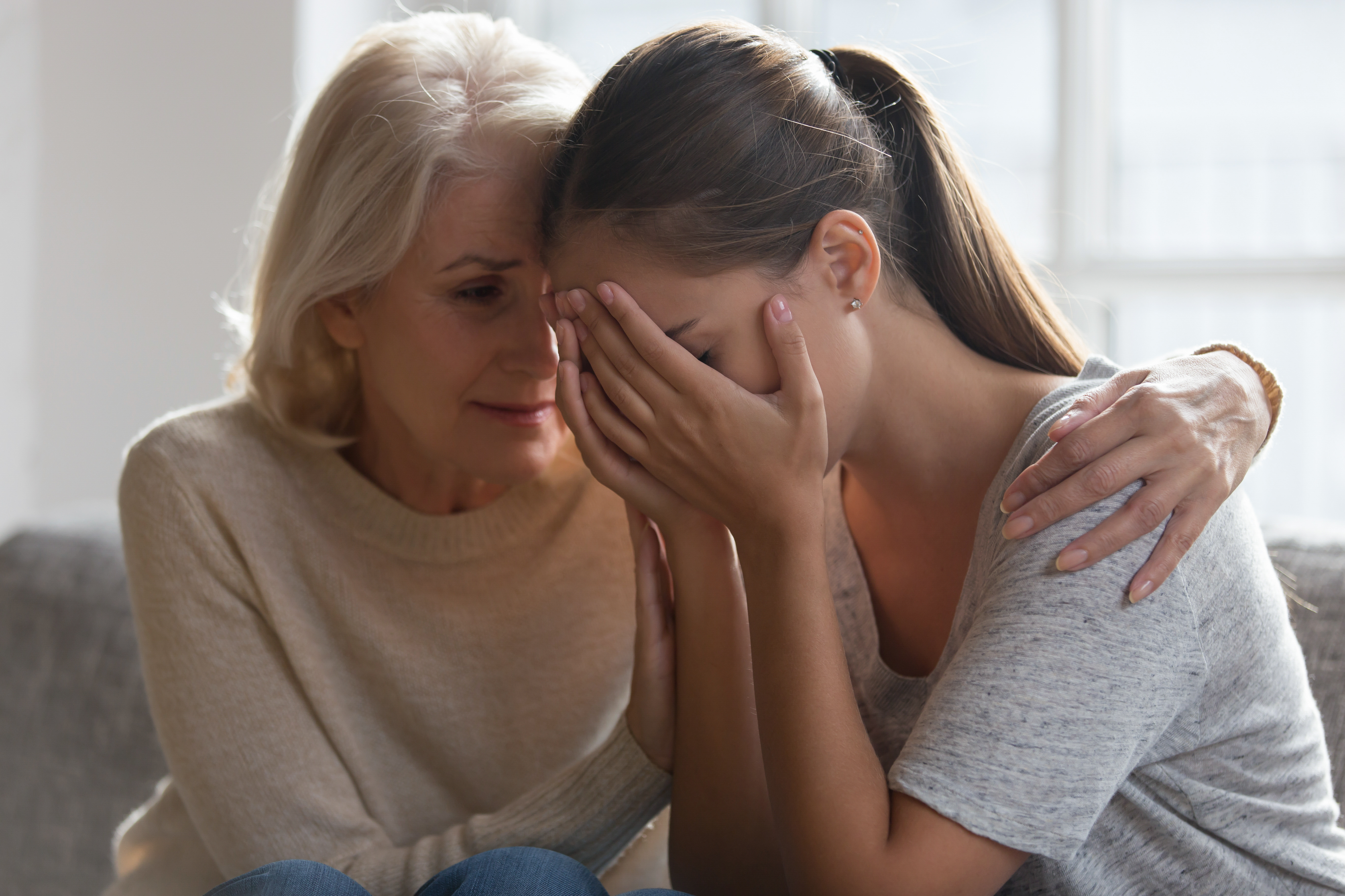 Besorgte Mutter tröstet ihre Tochter | Quelle: Shutterstock