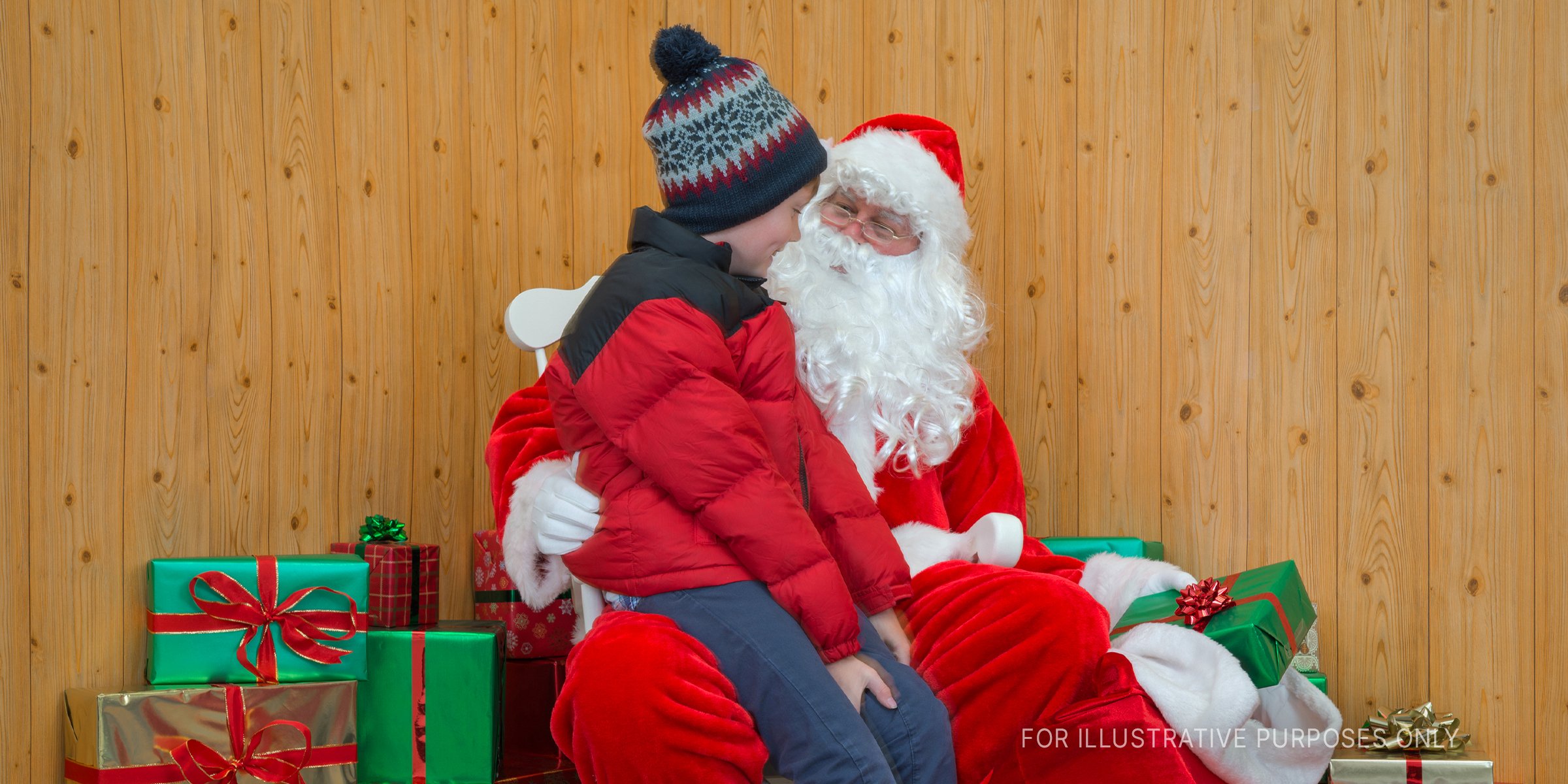 Der Weihnachtsmann sitzt mit einem Jungen zusammen | Quelle: Getty Images