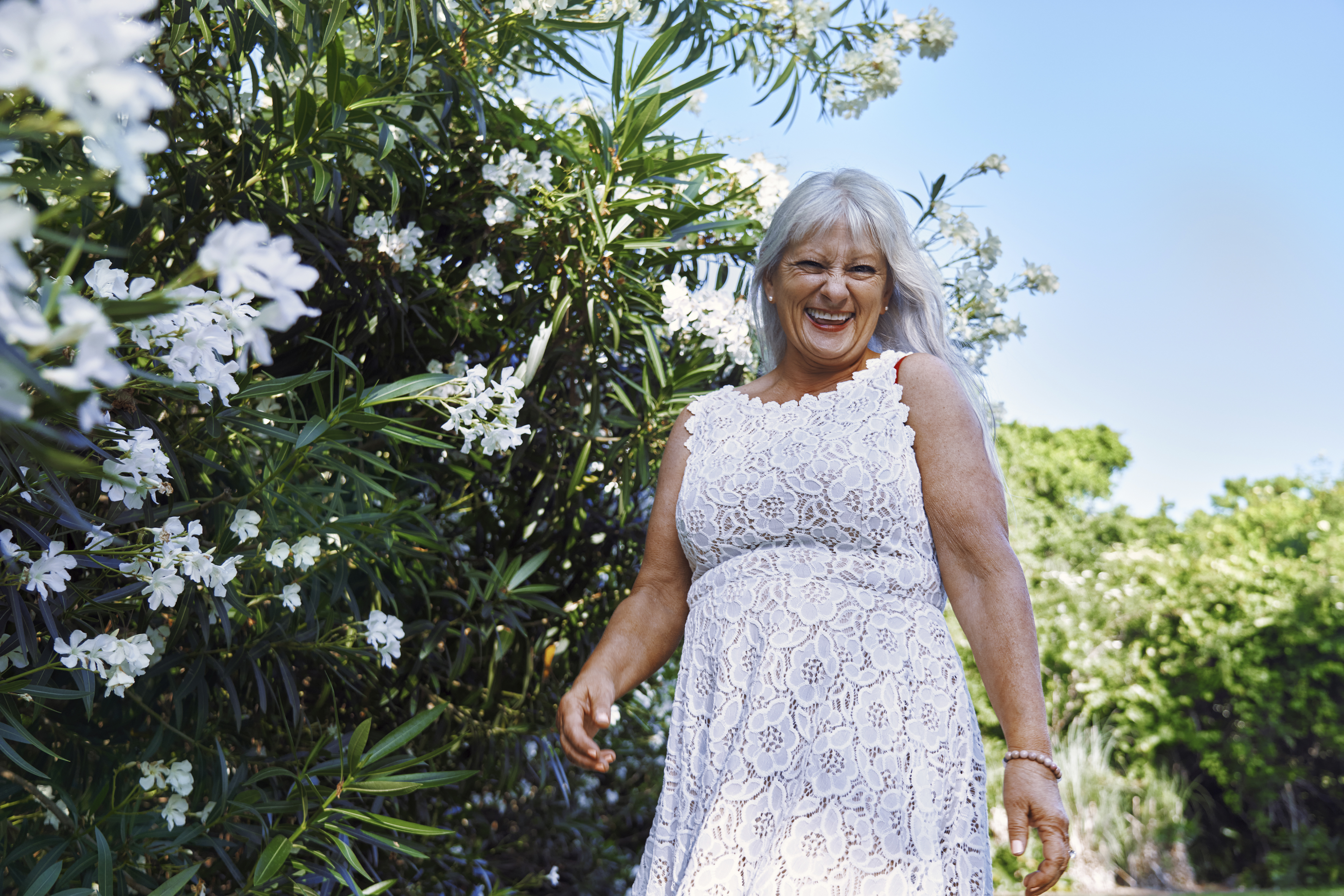 Glückliche Seniorin in einem weißen Kleid | Quelle: Getty Images