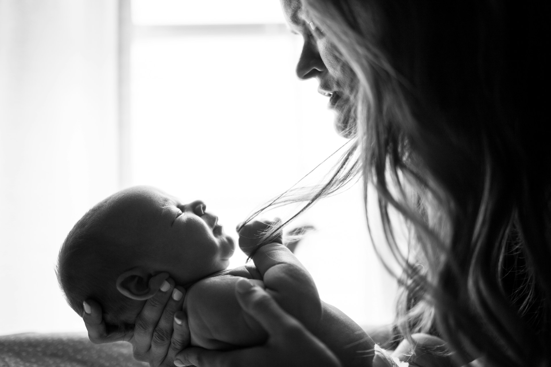 Eine traurige Mutter, die auf ihr Baby schaut | Quelle: Unsplash