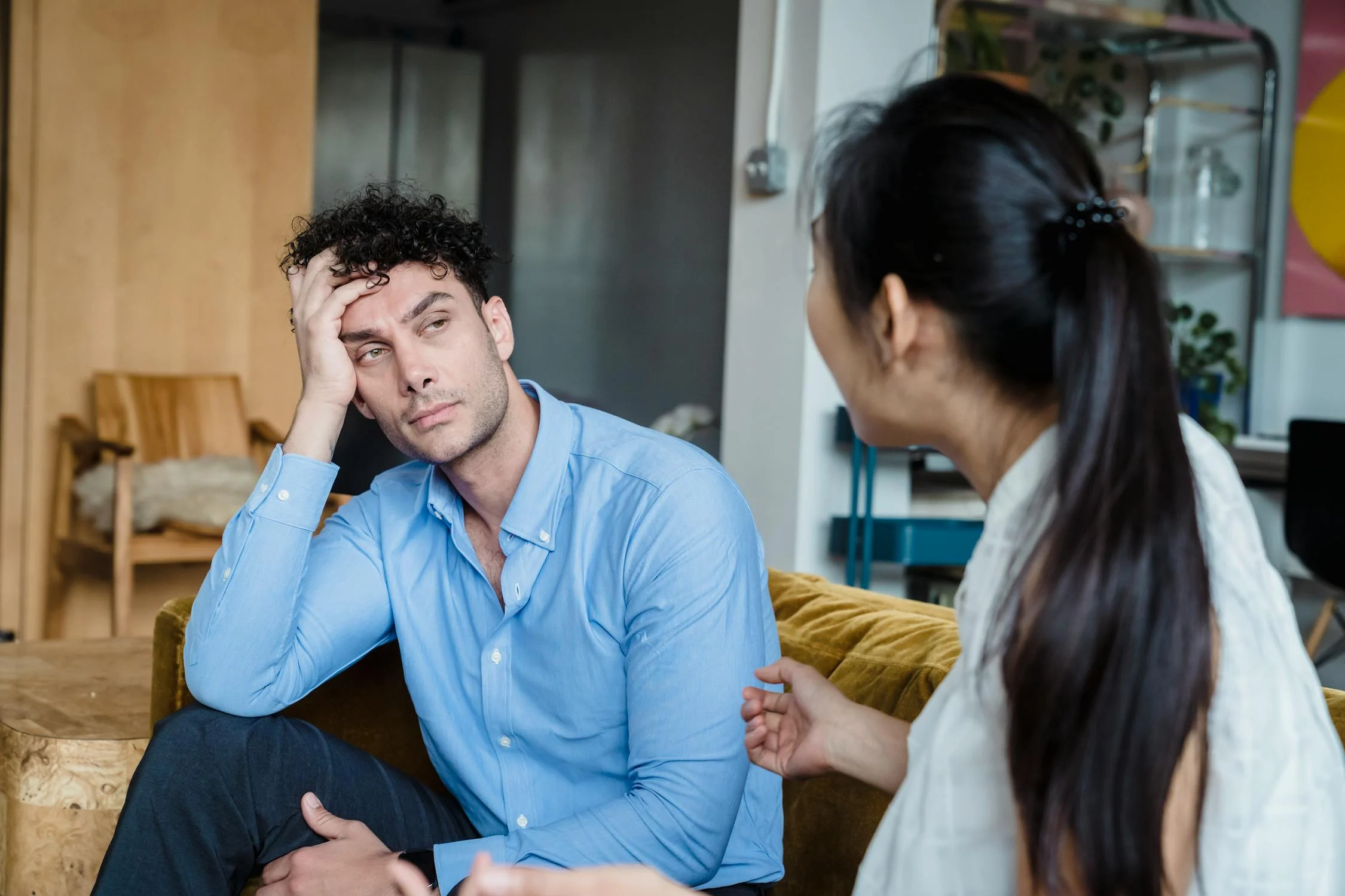 Eine Frau im Gespräch mit einem Mann in ihrem Wohnzimmer | Quelle: Pexels