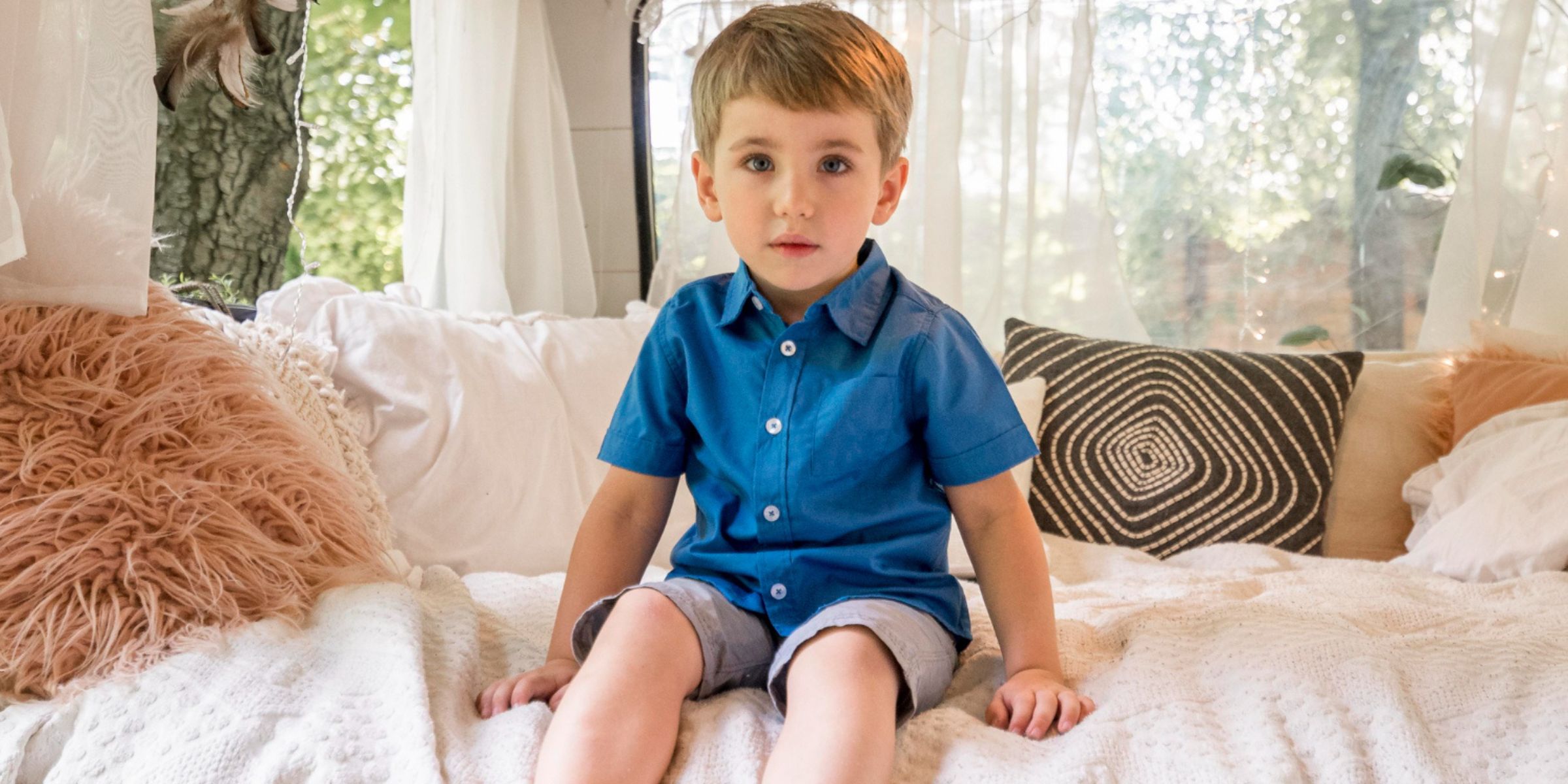 Ein kleiner Junge sitzt auf dem Bett | Quelle: Freepik