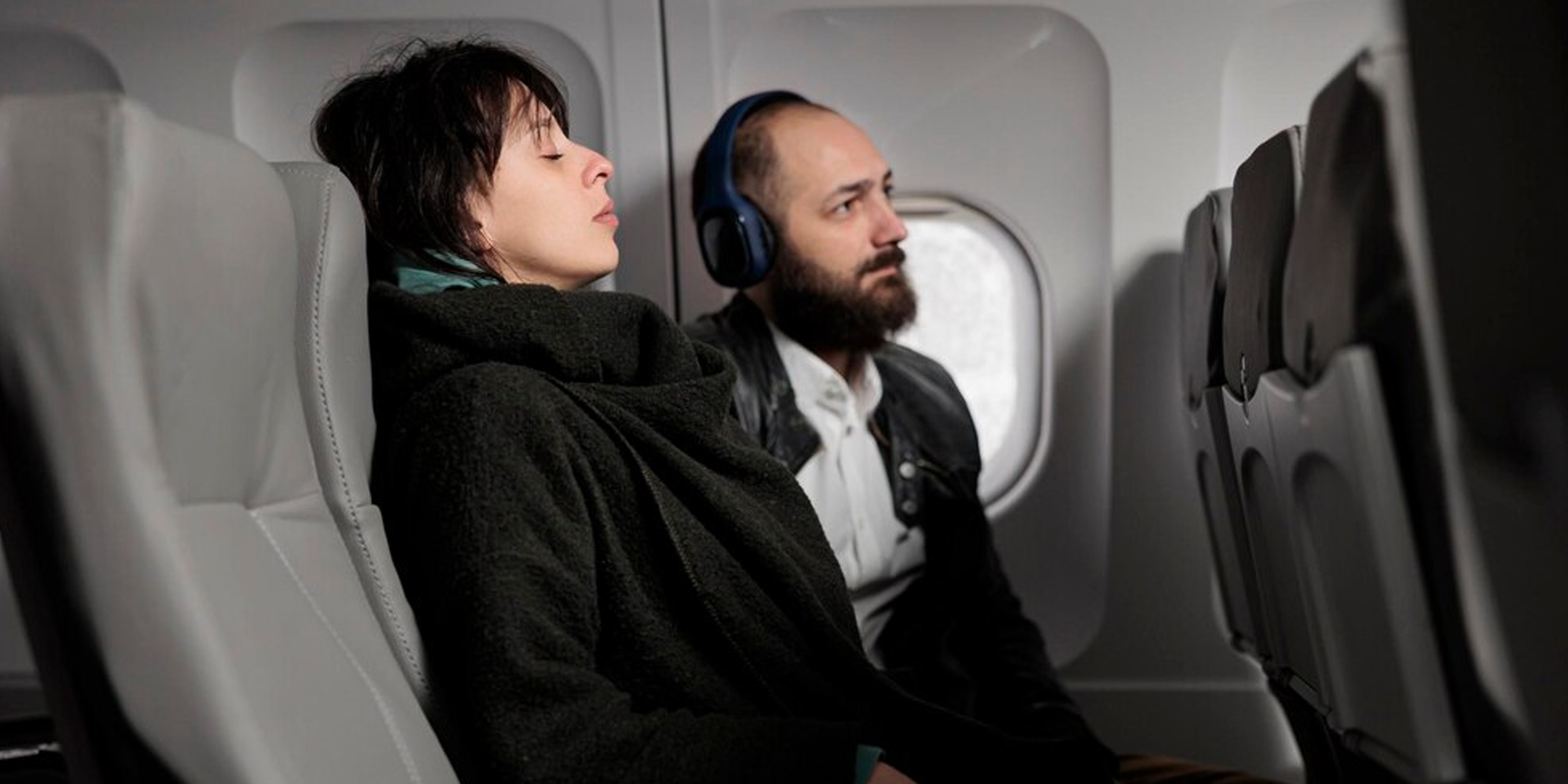 Ein Mann und eine Frau entspannen sich auf einem Flug | Quelle: Freepik.com/dcstudio