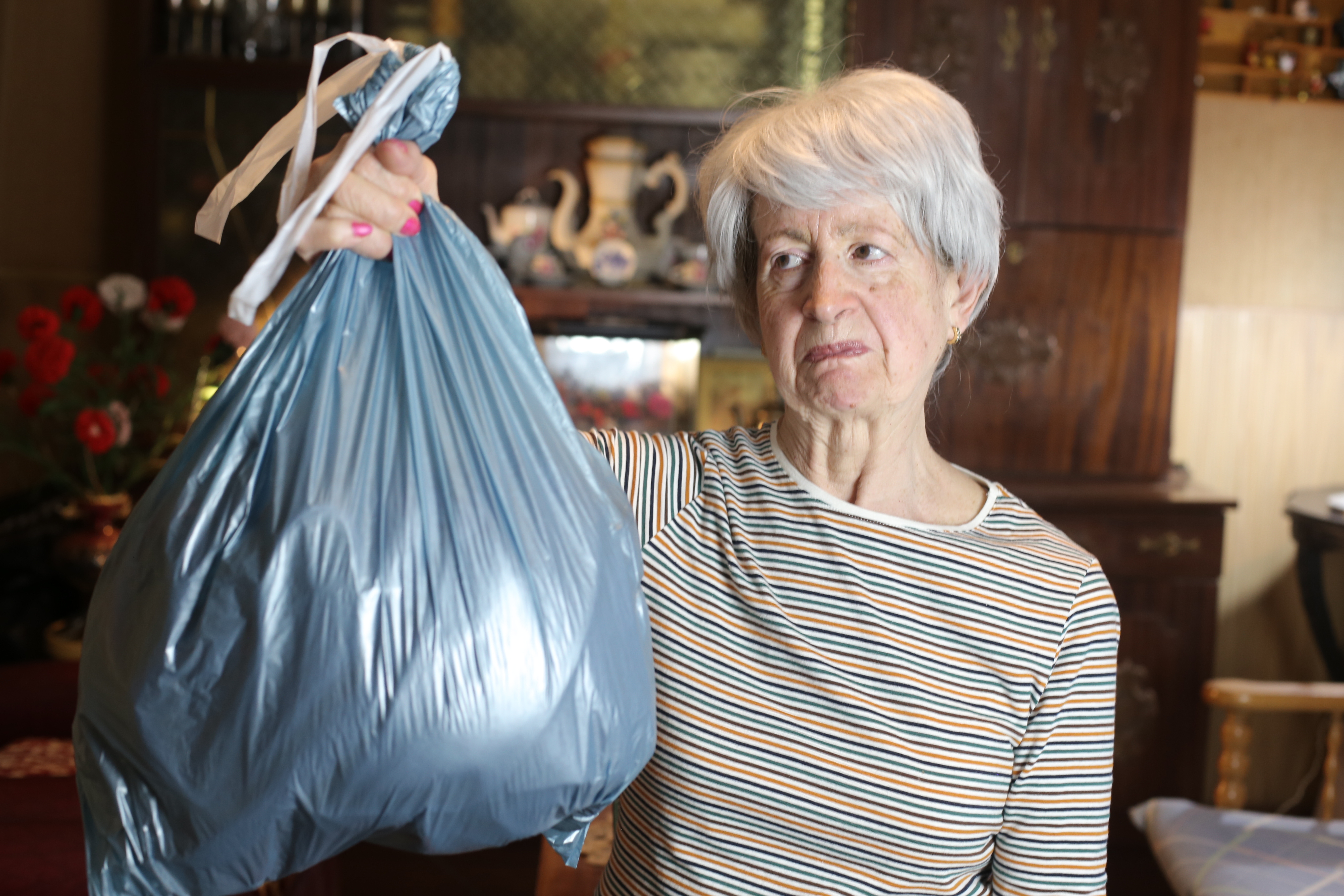 Ältere Frau hält einen Müllsack | Quelle: Getty Images