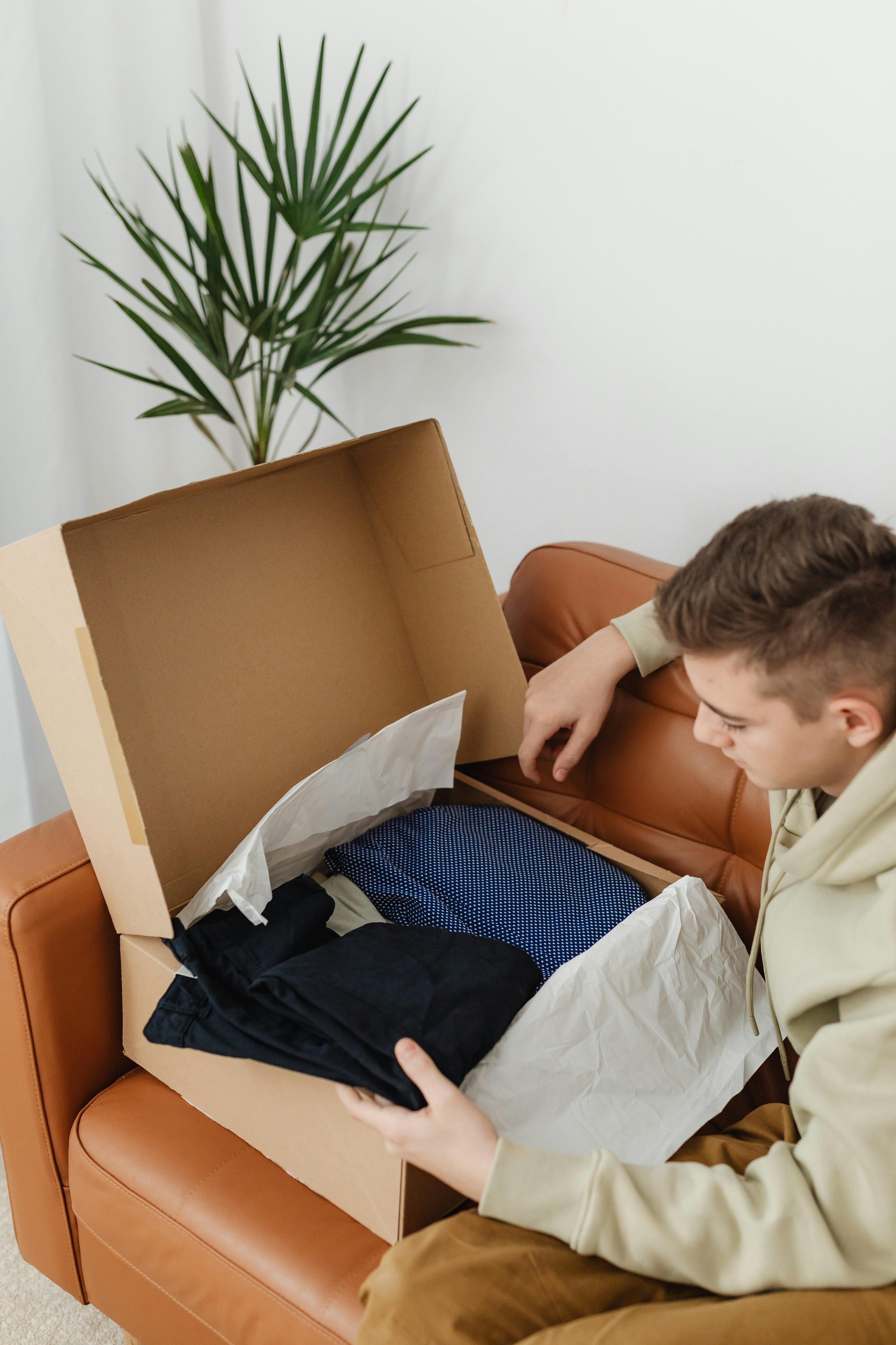 Ein Junge sieht sich neue Kleidung an | Quelle: Pexels