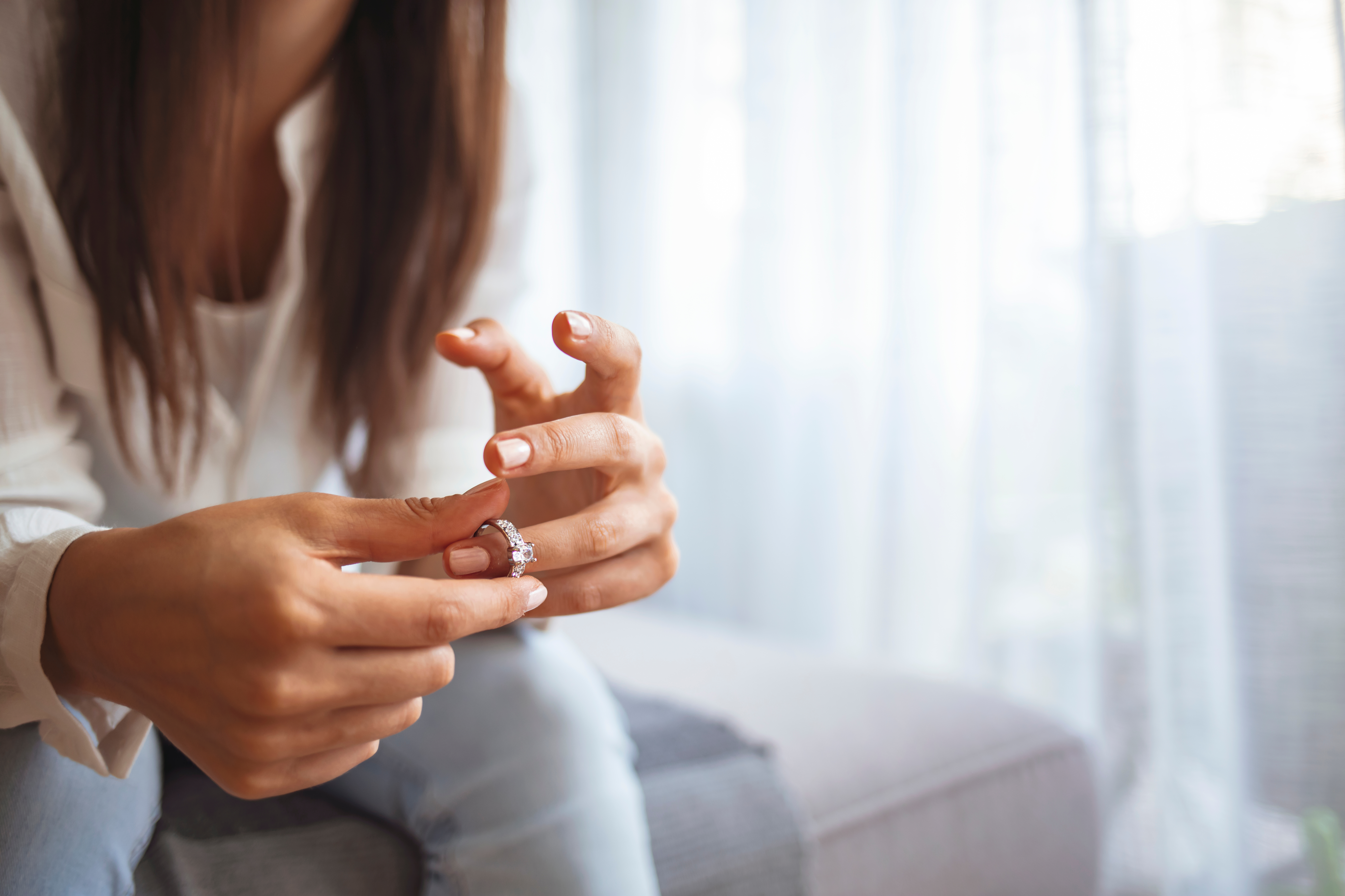 Eine deprimierte junge Frau, die ihren Ehering hält | Quelle: Shutterstock