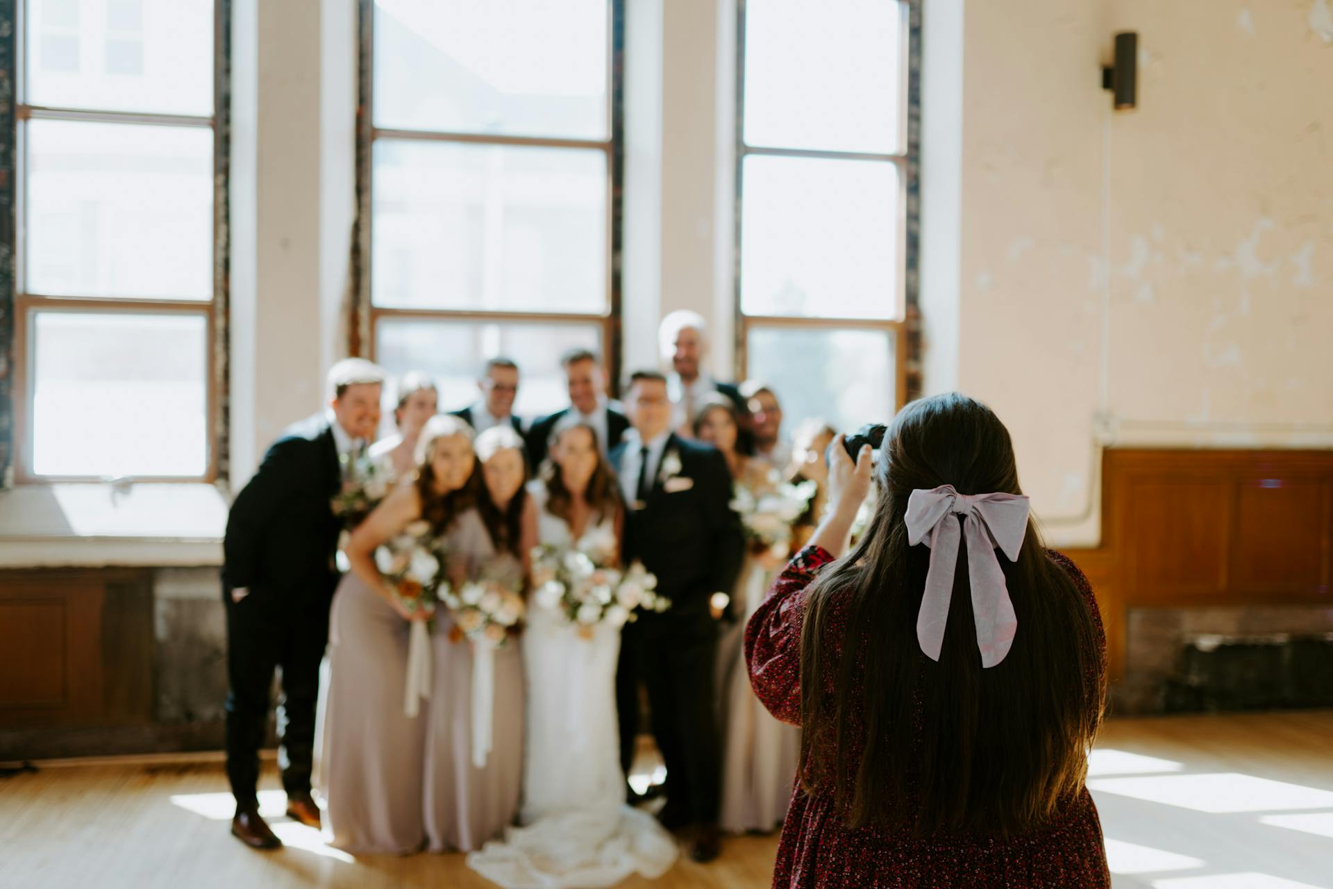 Eine Frau, die eine Gruppe bei einer Hochzeit fotografiert | Quelle: Pexels