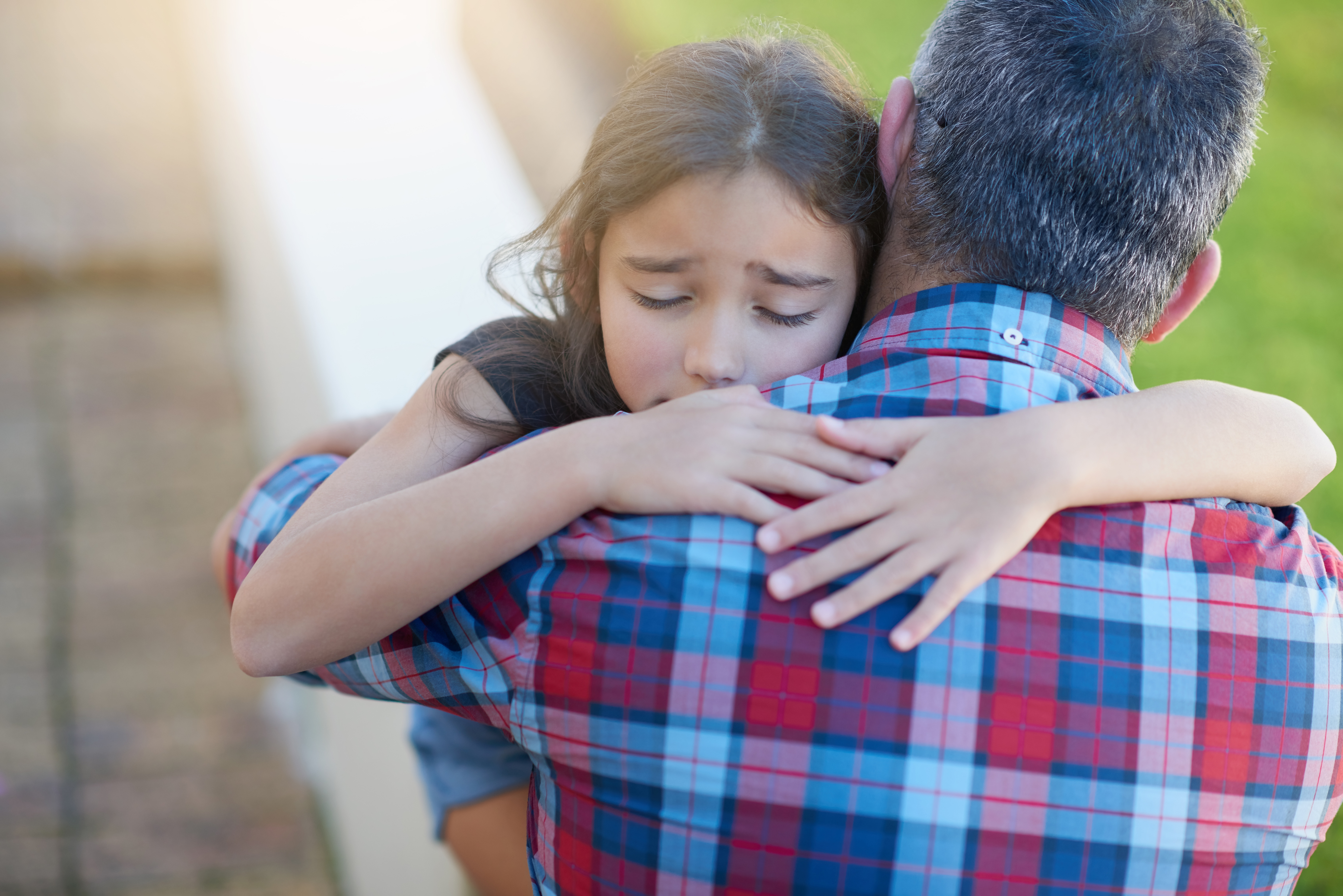 Vater tröstet seine verzweifelte kleine Tochter | Quelle: Shutterstock